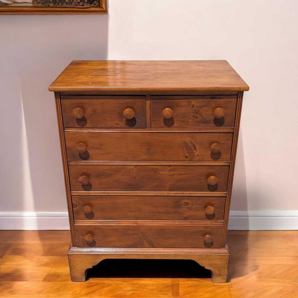 Une commode intemporelle en pin dans la tradition Shakers, fabriquée en bois massif et dotée de boutons ronds surdimensionnés, de pieds en équerre et de lignes épurées. Ce tallBoy à 6 tiroirs offre à la fois un charme visuel et un rangement