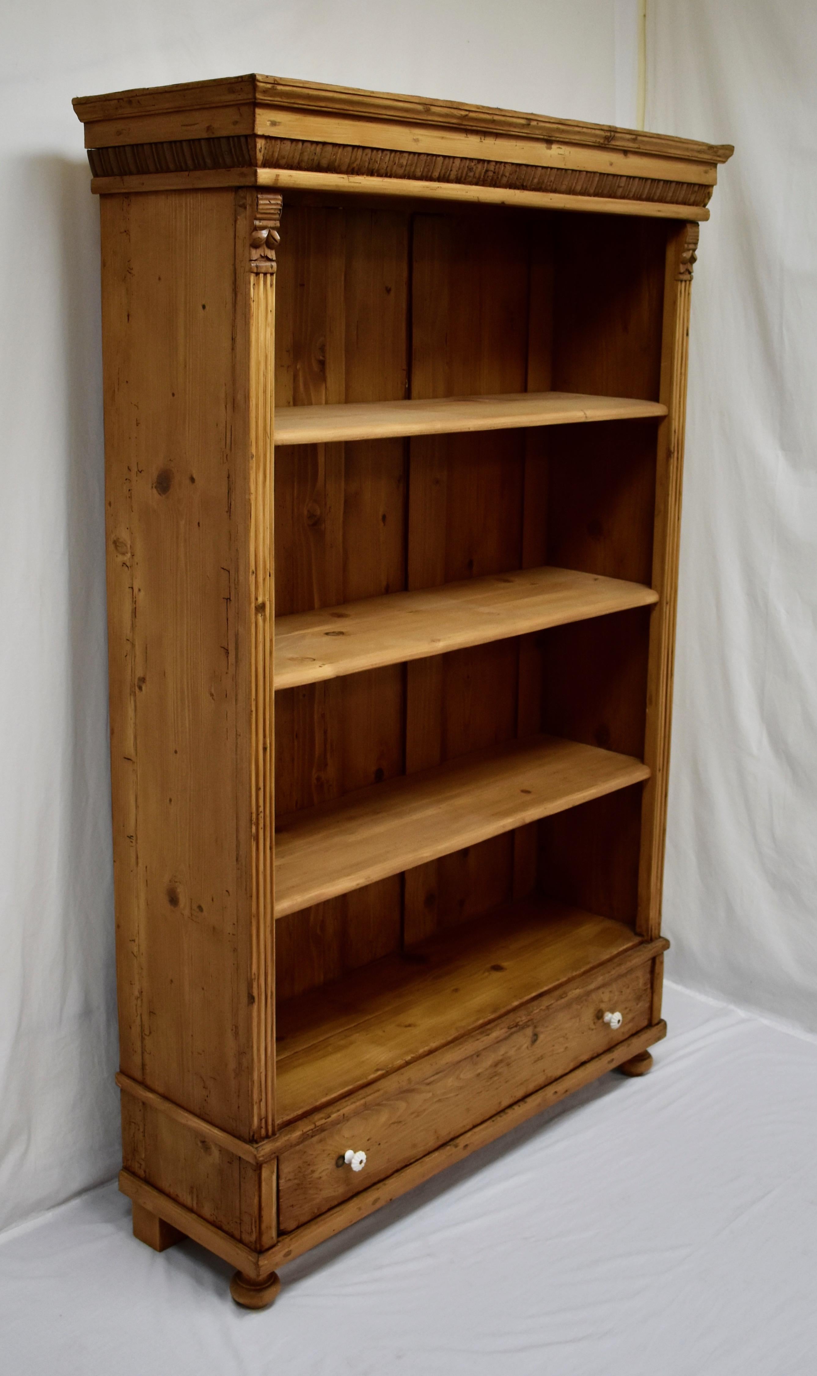 Antique pine bookcases are hard to find so the shell of this piece was provided by a vintage pine armoire, in this case one of considerable character, that had lost its doors, With one board width removed from the sides and the original backboards,