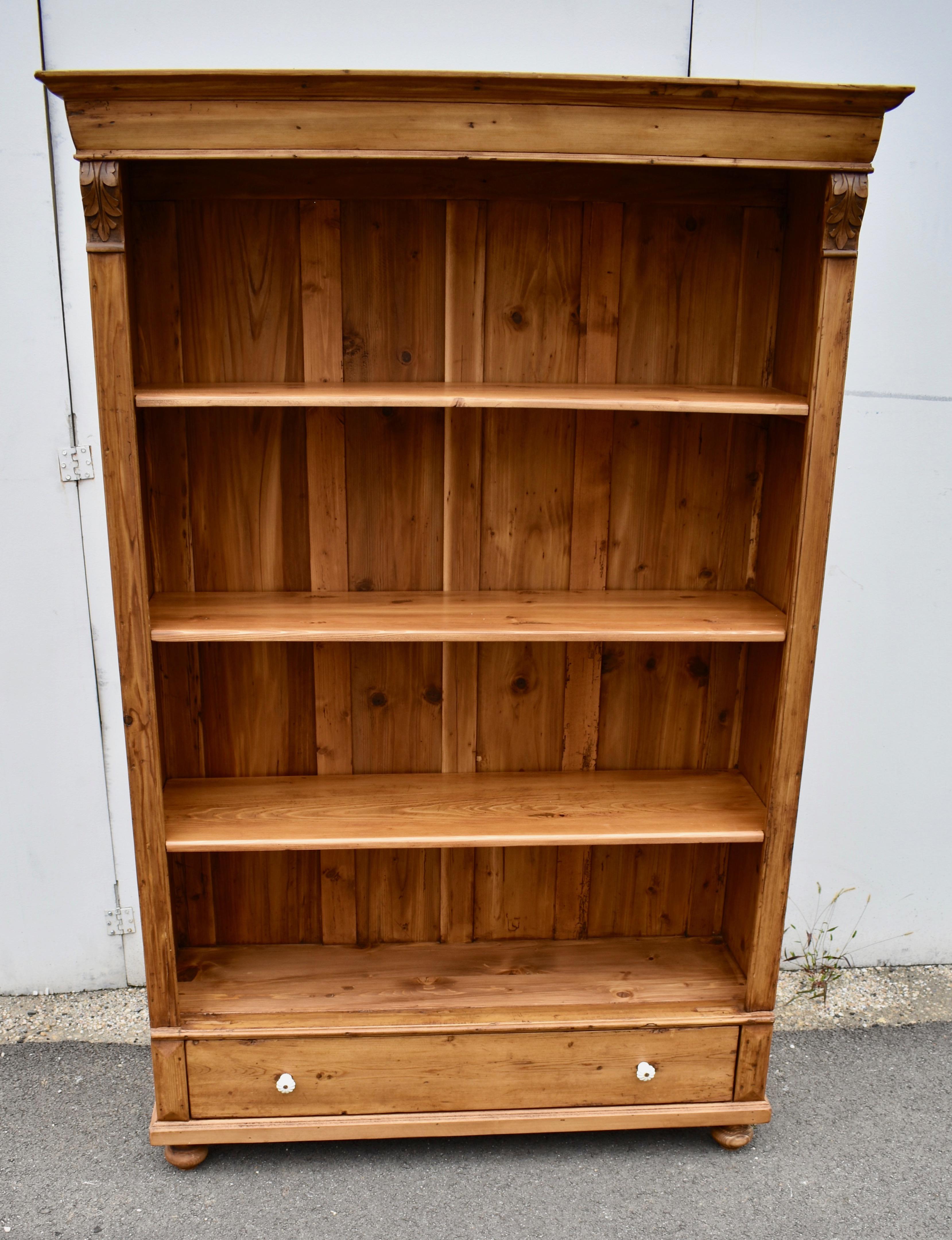 Antique pine bookcases are hard to find so the shell of this piece was provided by a vintage pine armoire.  With one board width removed from the sides and the original backboards and crown molding retained, with the drawer reduced in depth, we get