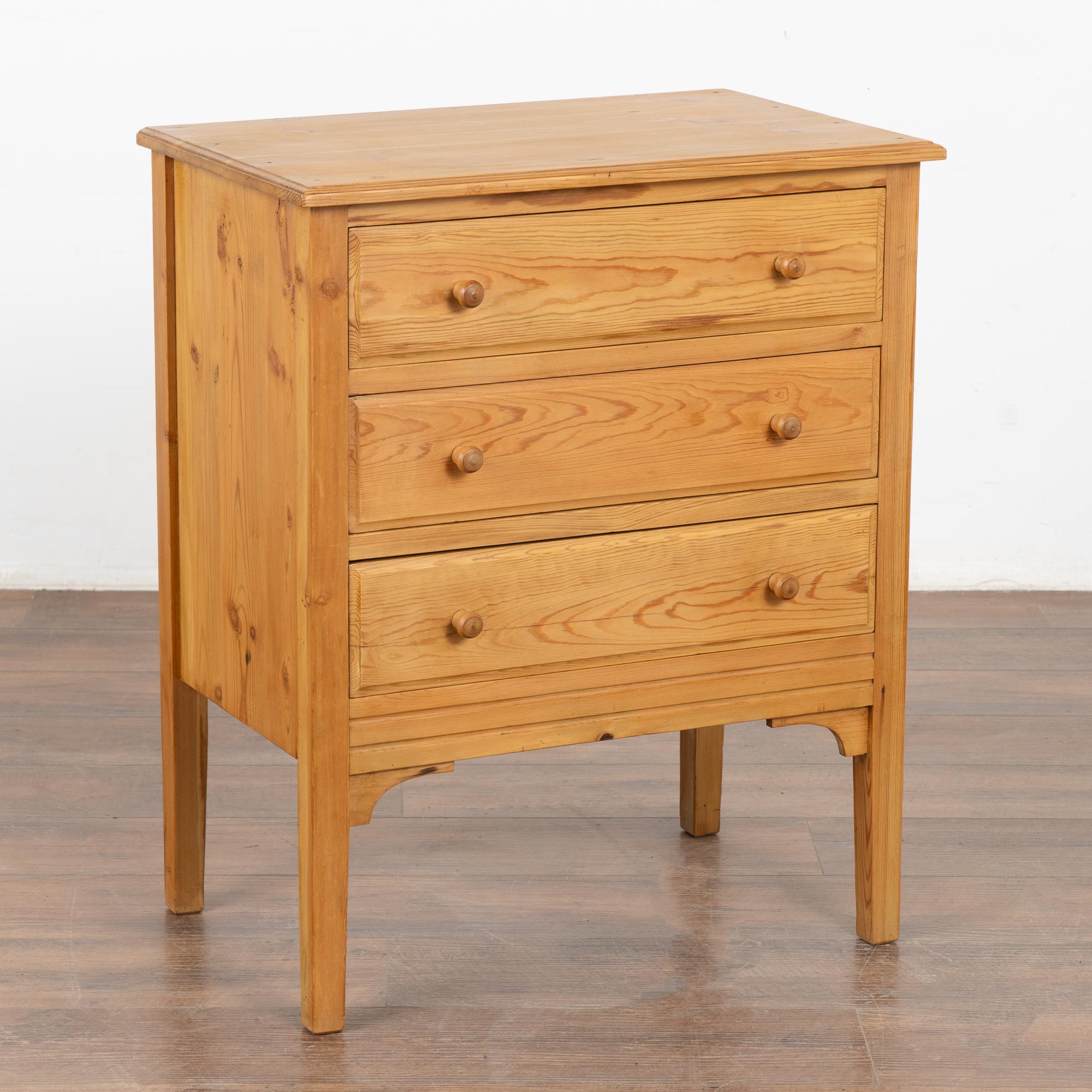Antique pine nightstand or small chest of three drawers with clean lines.
Note the natural wax finish that brings out the warmth of the pine. 
Restored, this nightstand is strong, stable and ready for use.
Drawers function, open with wood pulls.
Any