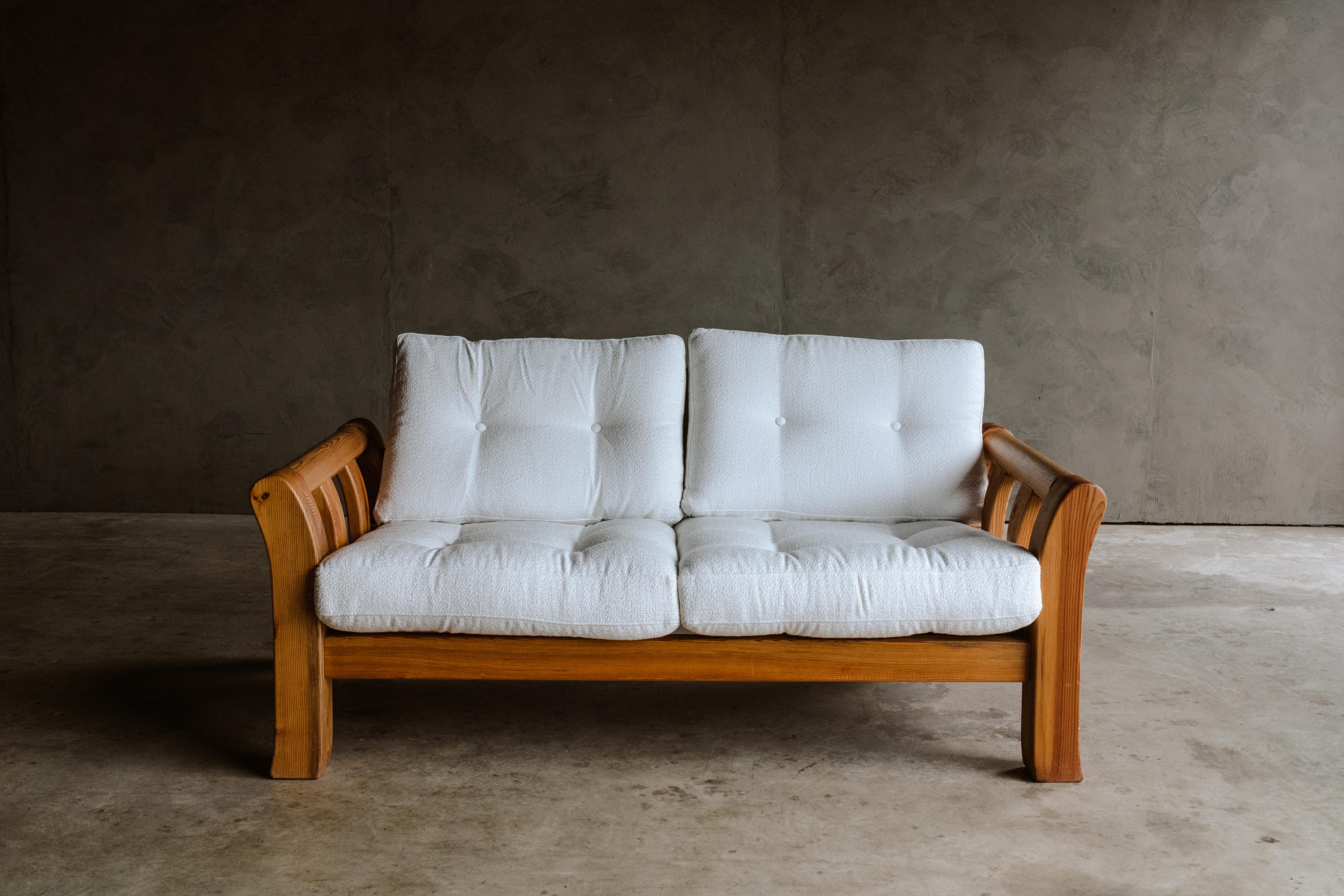 Vintage pine sofa from Denmark, Circa 1960. Solid pine construction with off white upholstered cushions. Light wear and patina.