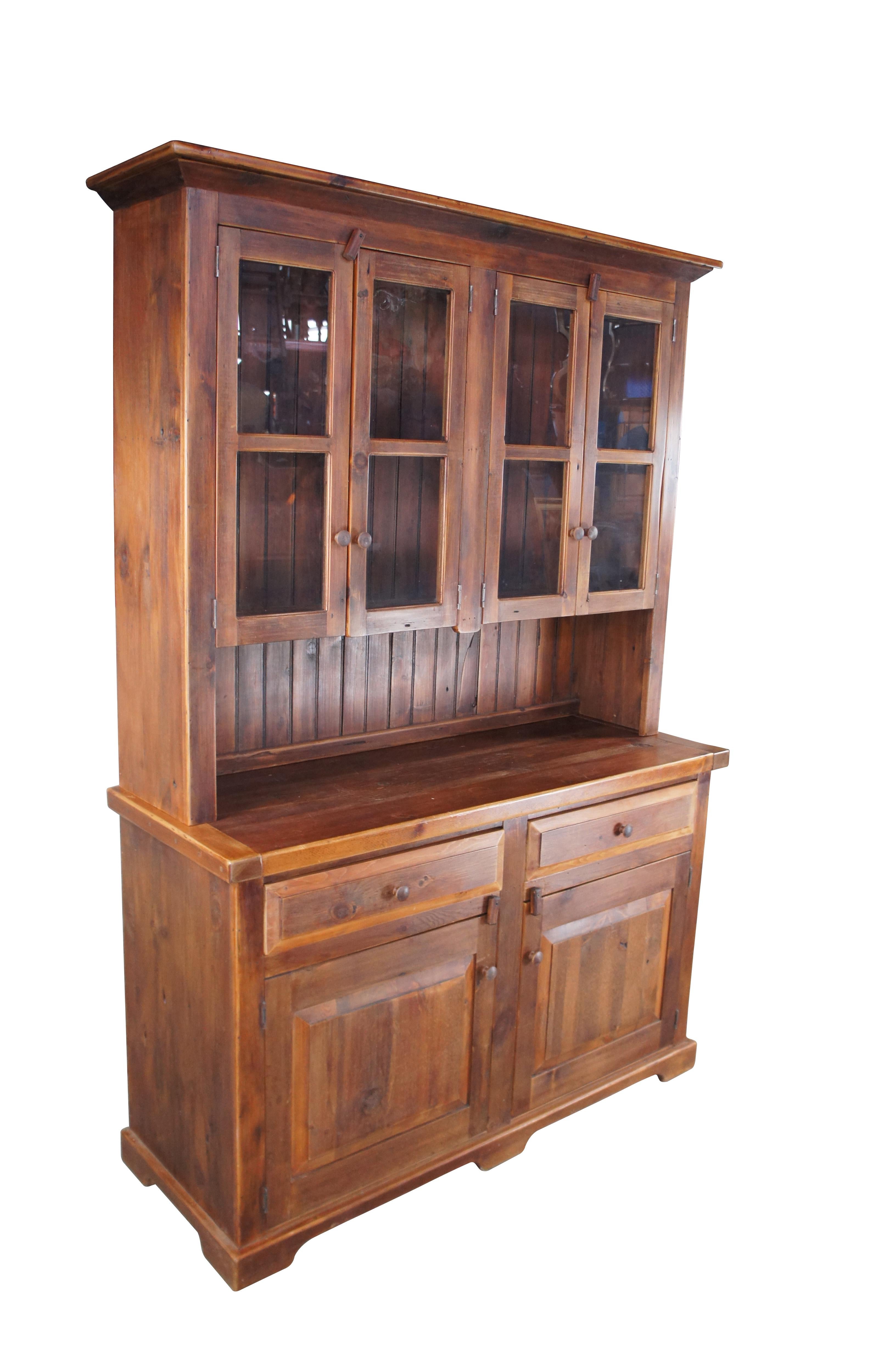 Vintage stepback cupboard in the manner of Pennsylvania Dutch. Made of pine featuring early American styling with upper curio display over two drawers and lower storage cabinet. 

Dimensions:
54