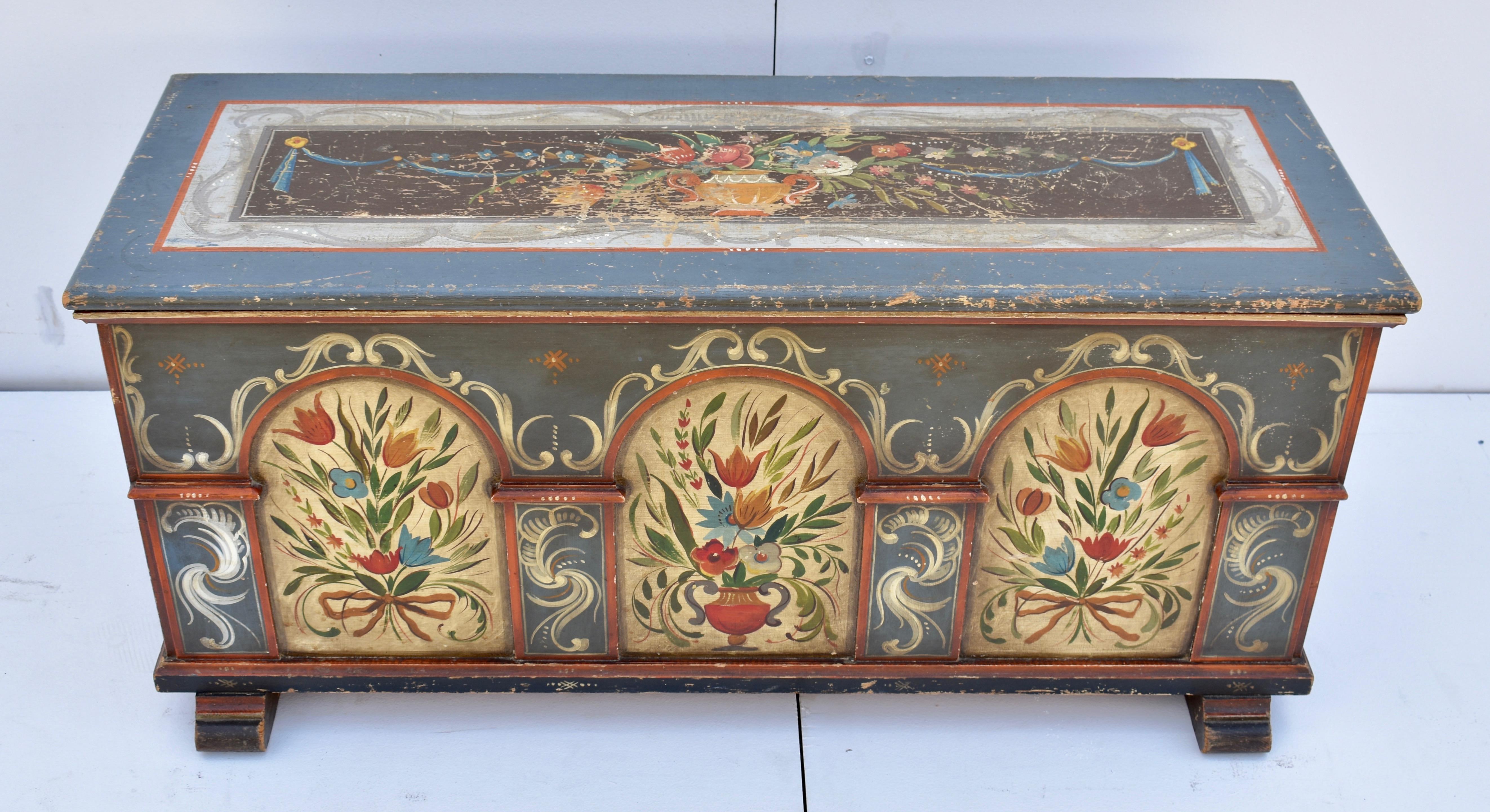 Though it is not a genuine period piece, this mid-twentieth century blanket chest is made in the old way and employs an energetic interpretation of traditional central European design motifs. On the sides, colorful ribbon-tied bouquets on a dark