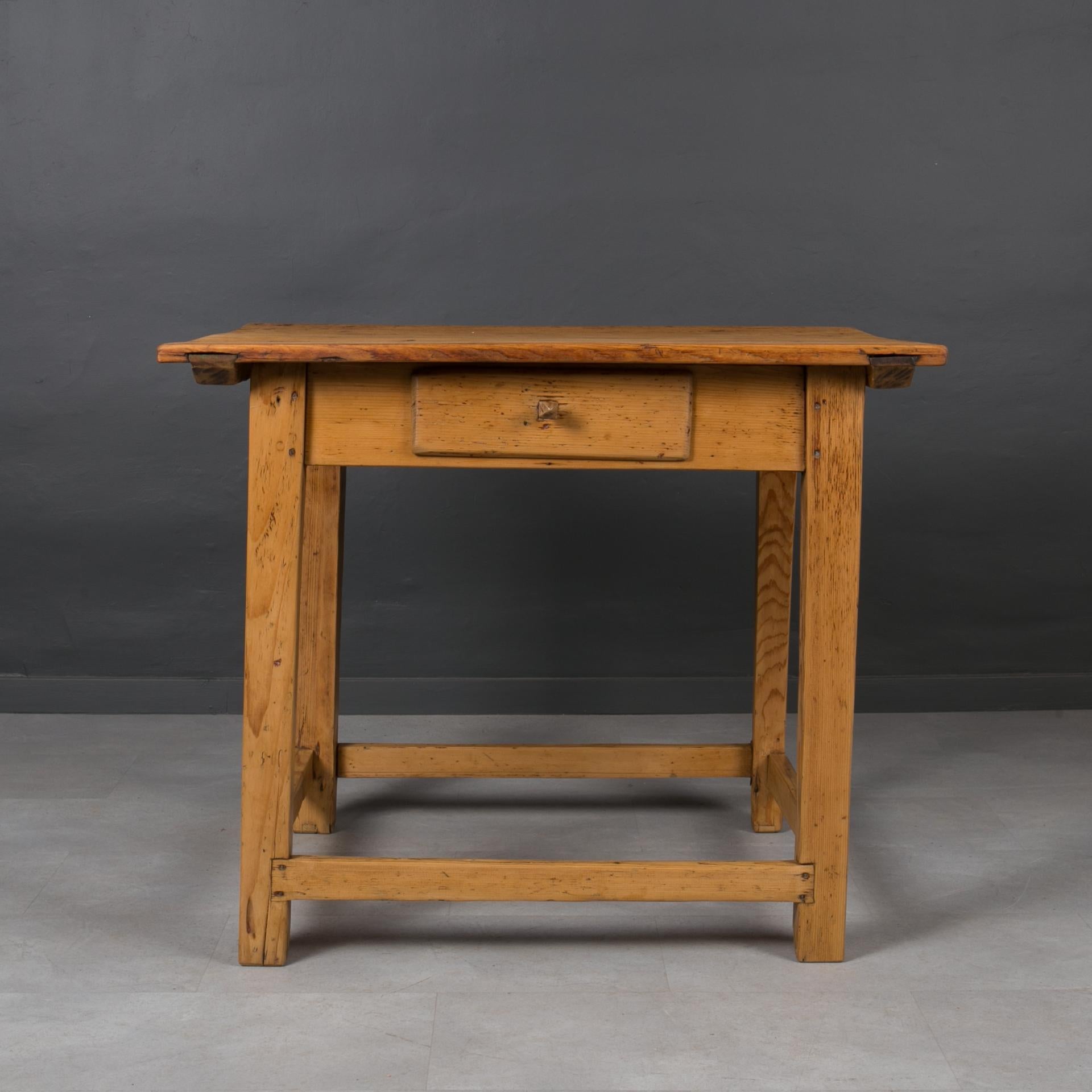 This charming vintage table was made in late 19th Century in Hungary. The whole piece is made of pine wood. The top is set on a solid base with a wide apron. One practical drawer resides in the apron. The piece was gently refreshed and finished with