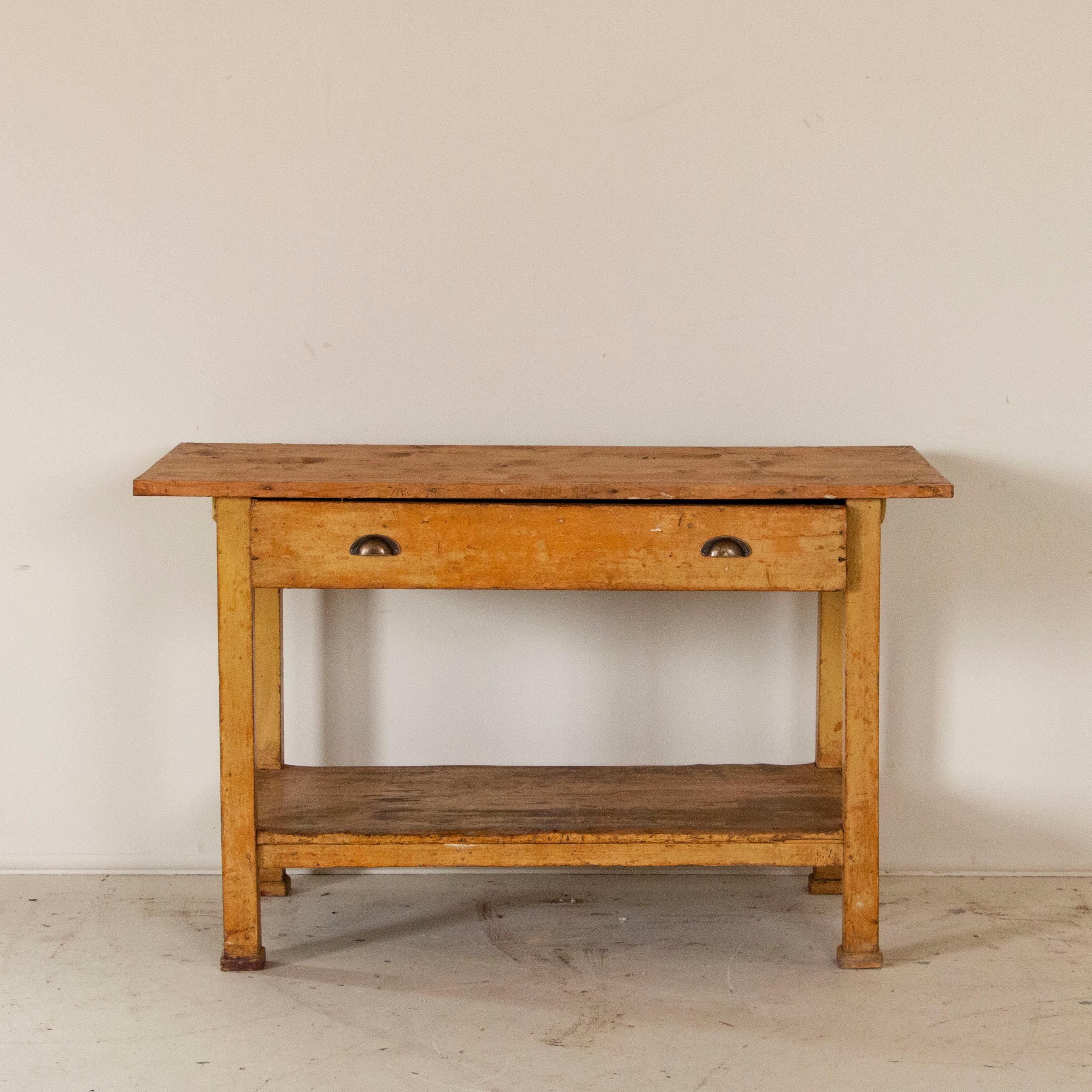 It is the many years of use that fill this old work table with such tremendous character. Notice the base still maintains its original, earth-tone paint while the top is all natural pine distressed to a deeper patina over time. The size of this