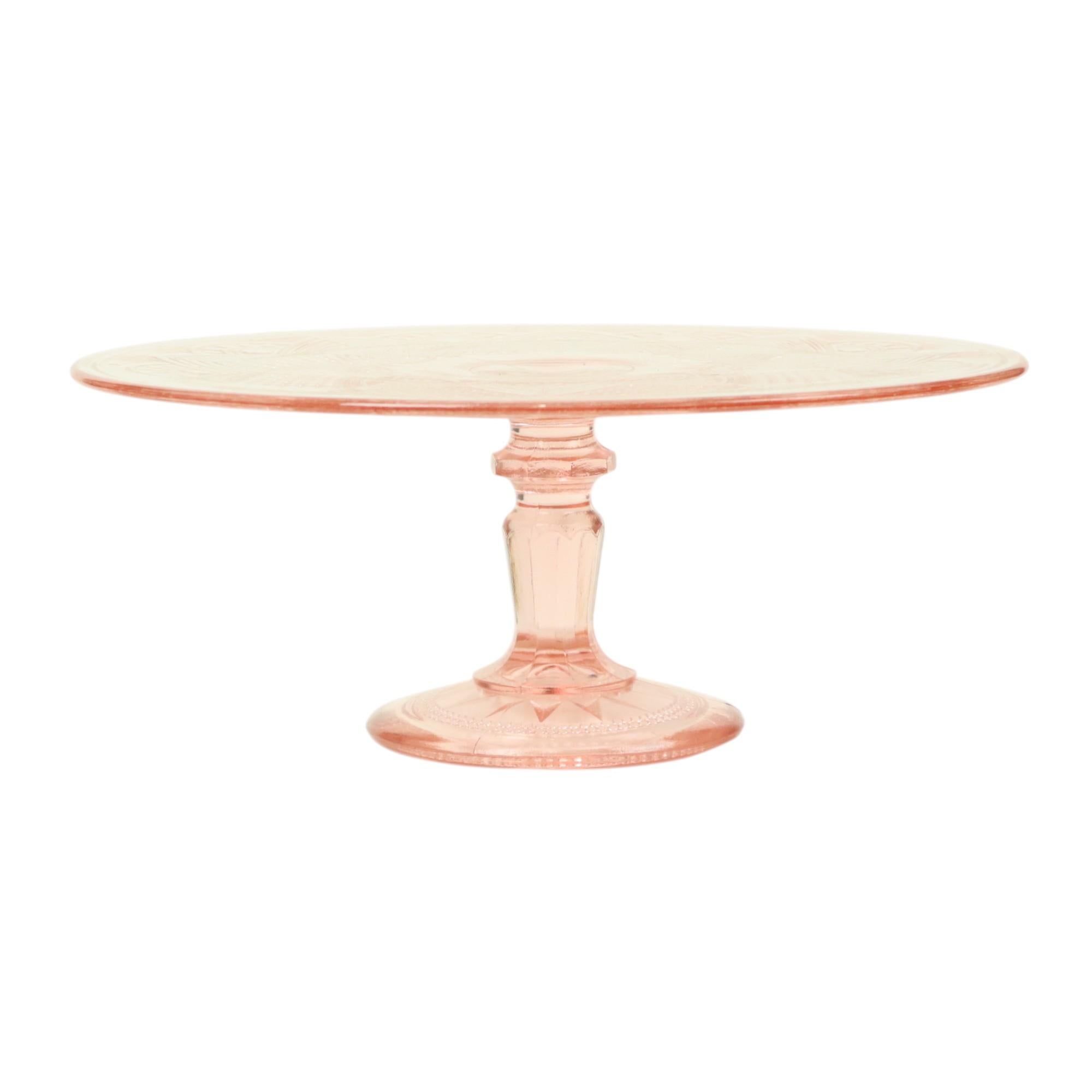 Beautiful vintage pink cake stand with a diamond pattern and embossed star motif, made of pressed glass, better known as Depression glass, first half of the 20th century, unmarked.

This cake stand contains air bubbles, glass threads, and small