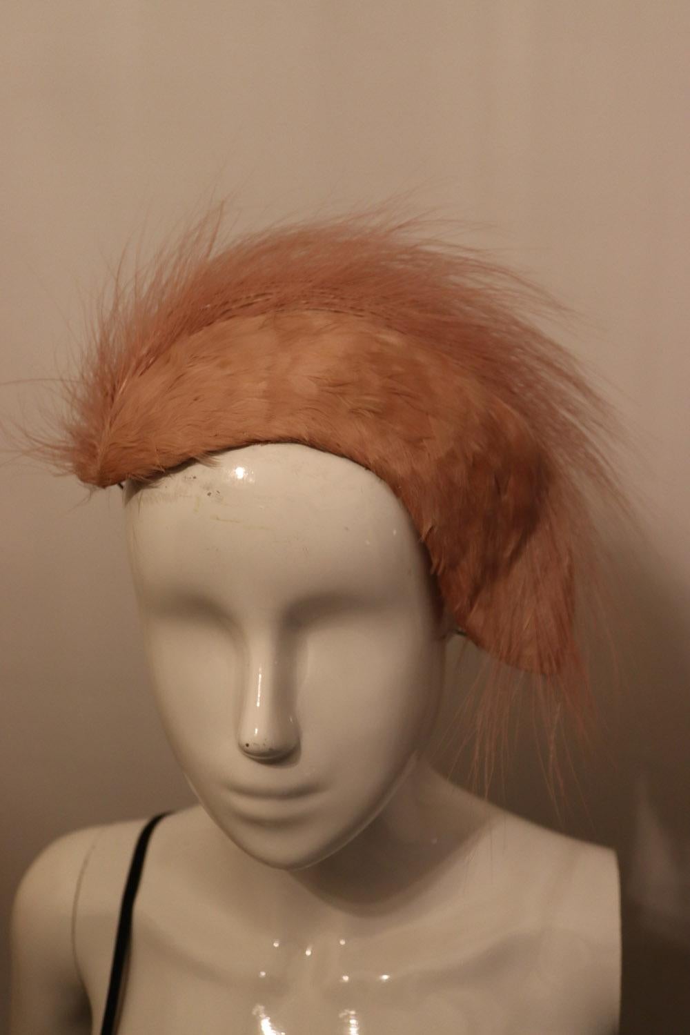 A stunning vintage head piece /band in pink feathers. The feathers are arranged in an attractive pattern and the headpiece is in excellent condition.
Measurements: Width 11'' x height 6''