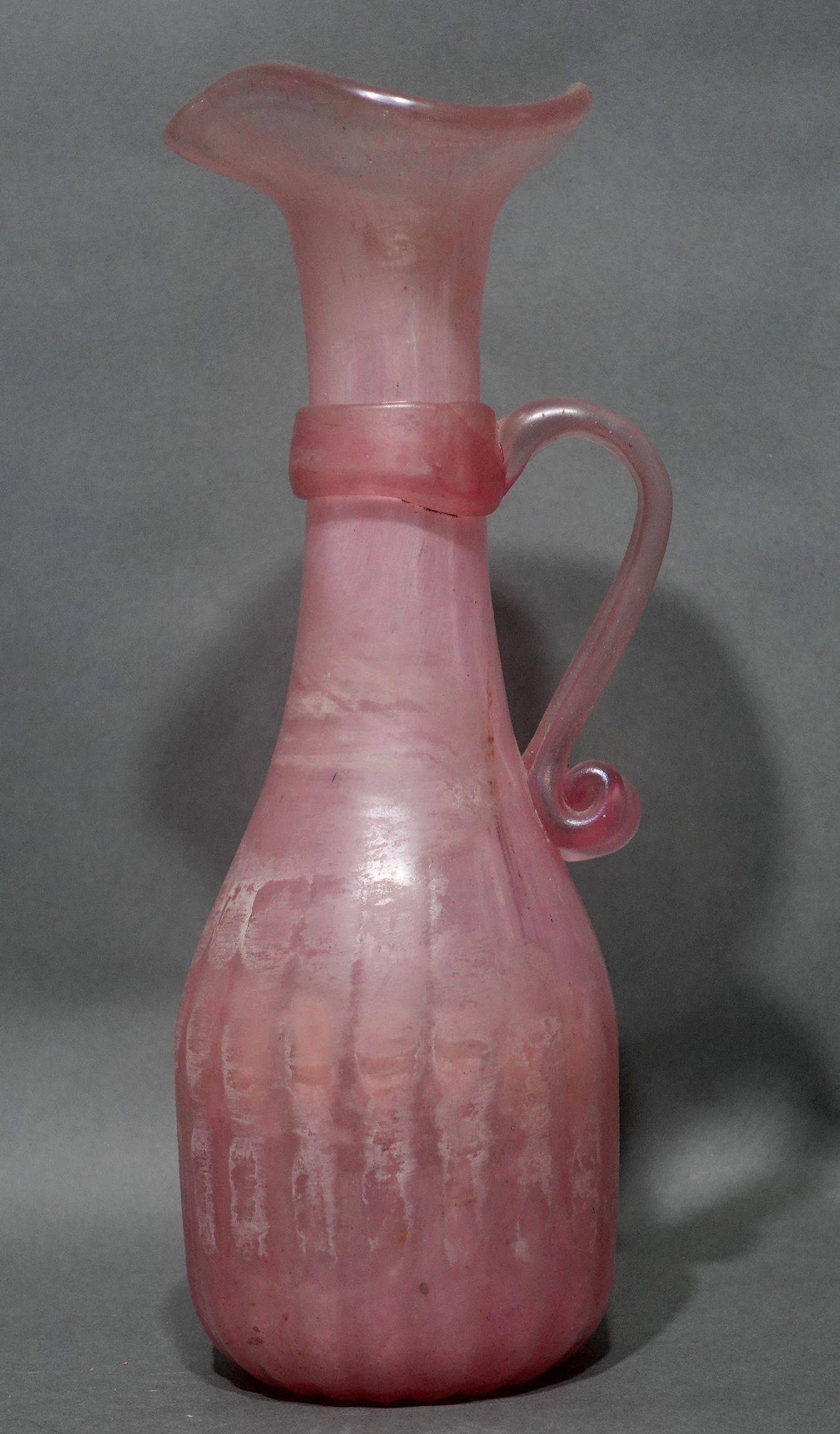 Beautiful Vintage opaque pink Italian art glass pitcher. Handcrafted and hand blown. Surface wear is consistent with exposure with polished pontils on the bottom. Measures approx. 4.5 inches wide and 12 inches tall. New old inventory, made in Italy.
