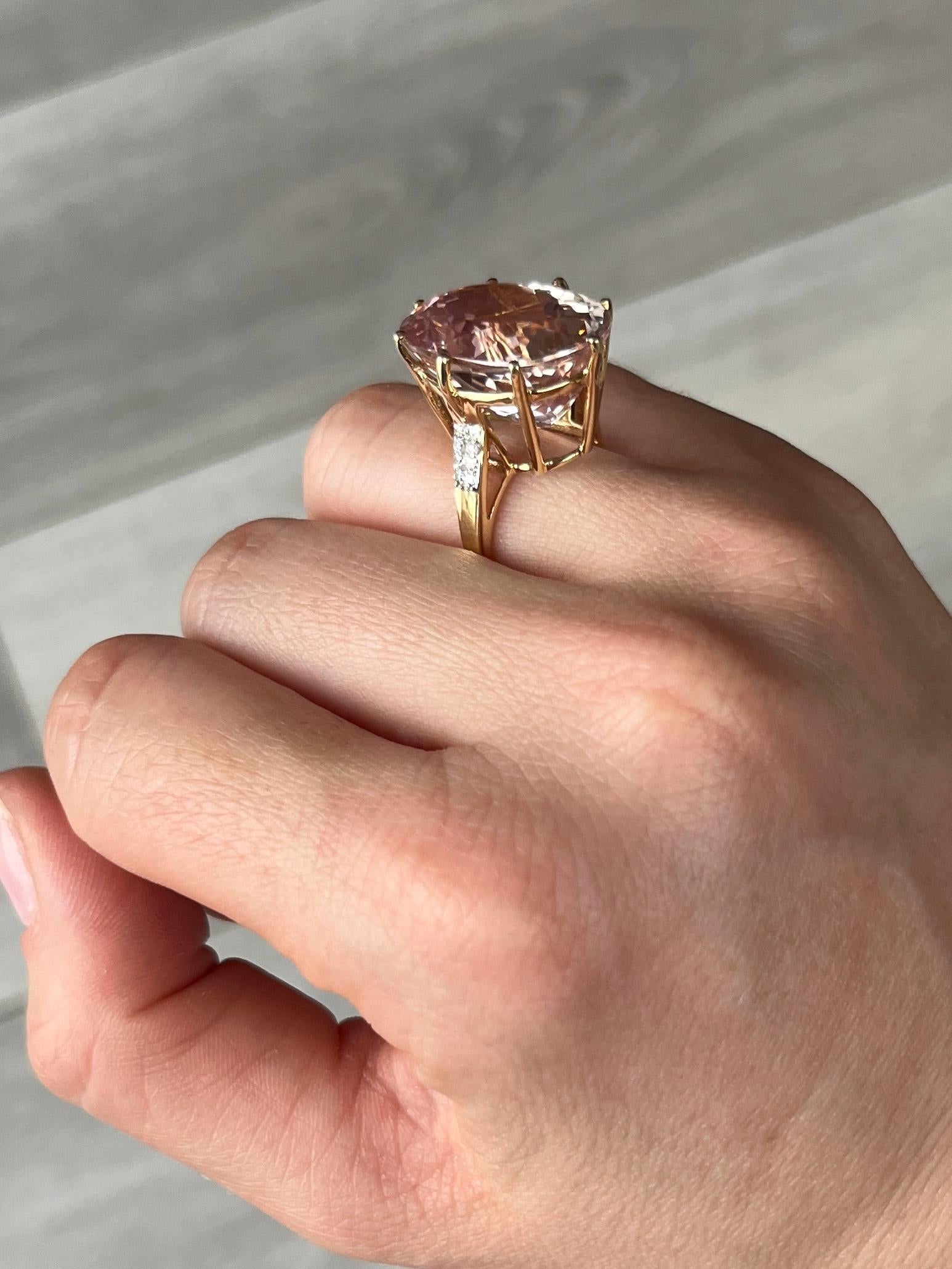 The fabulous large kunzite is cut to really show off the sparkle and colour of the stone and is set in a simple claw setting and sits up high on the 14 carat yellow gold ring. The shoulders each hold a pair of sparkling diamonds.

Ring Size: J 1/2
