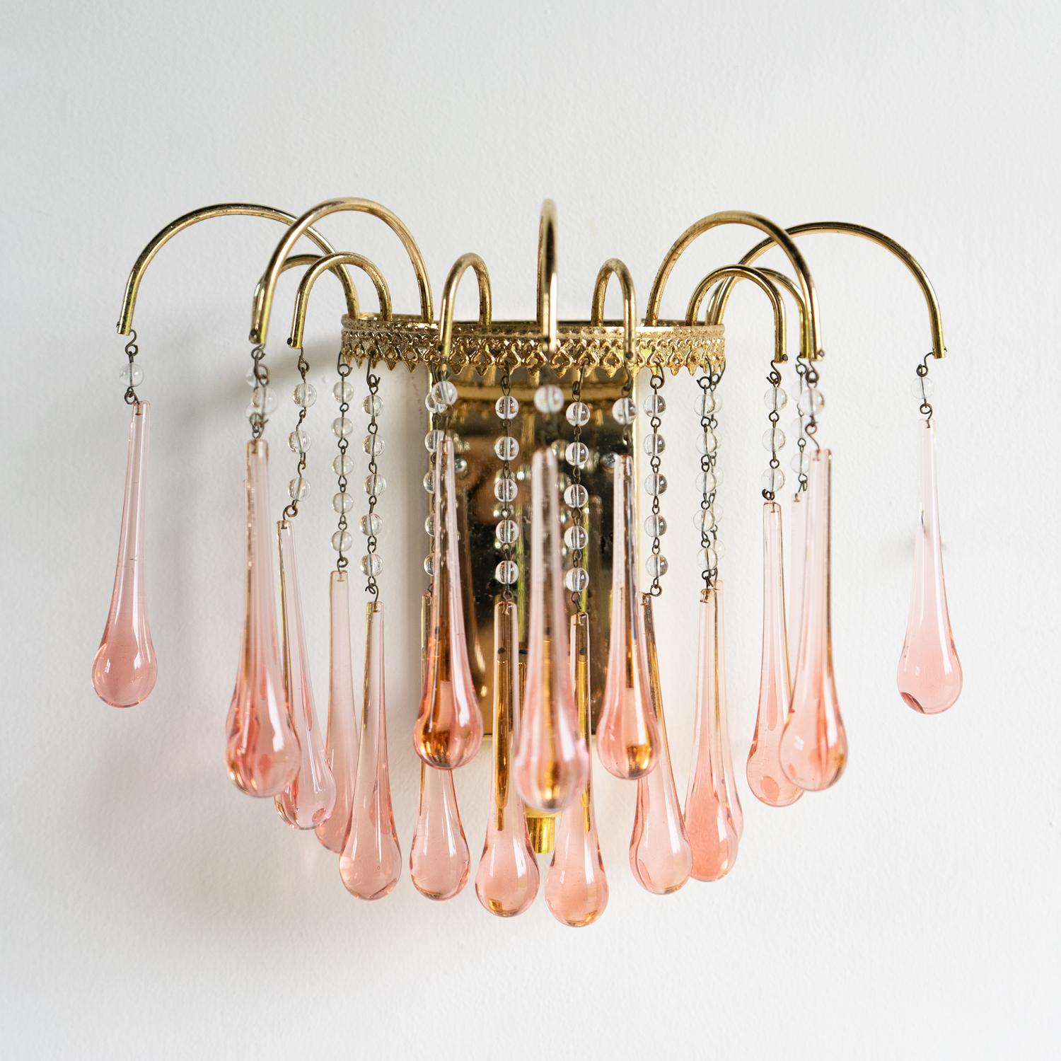 VINTAGE WALL MOUNTED SCONCE

Handblown peachy pink glass teardrop and cut crystal droplets on a gilt frame.

It is in very good vintage condition. There is some minor tarnishing to the gilt metal finish, but not too much that you would notice when