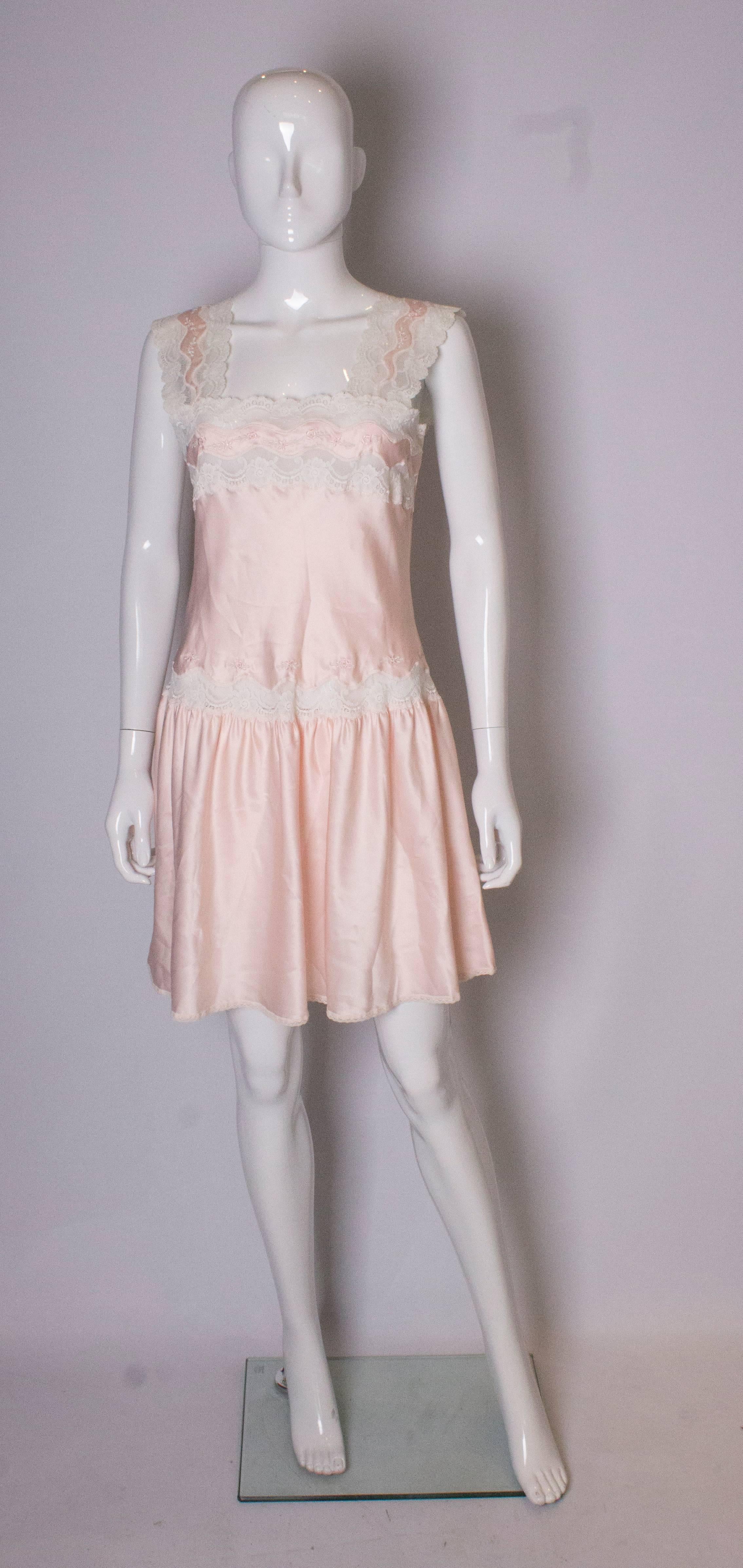 A charming vintage dress ( or nightdress ) by Marks and Spencer. In a pale pink with lace and embroidery trim, the dress has a drop waist and wide shoulders.