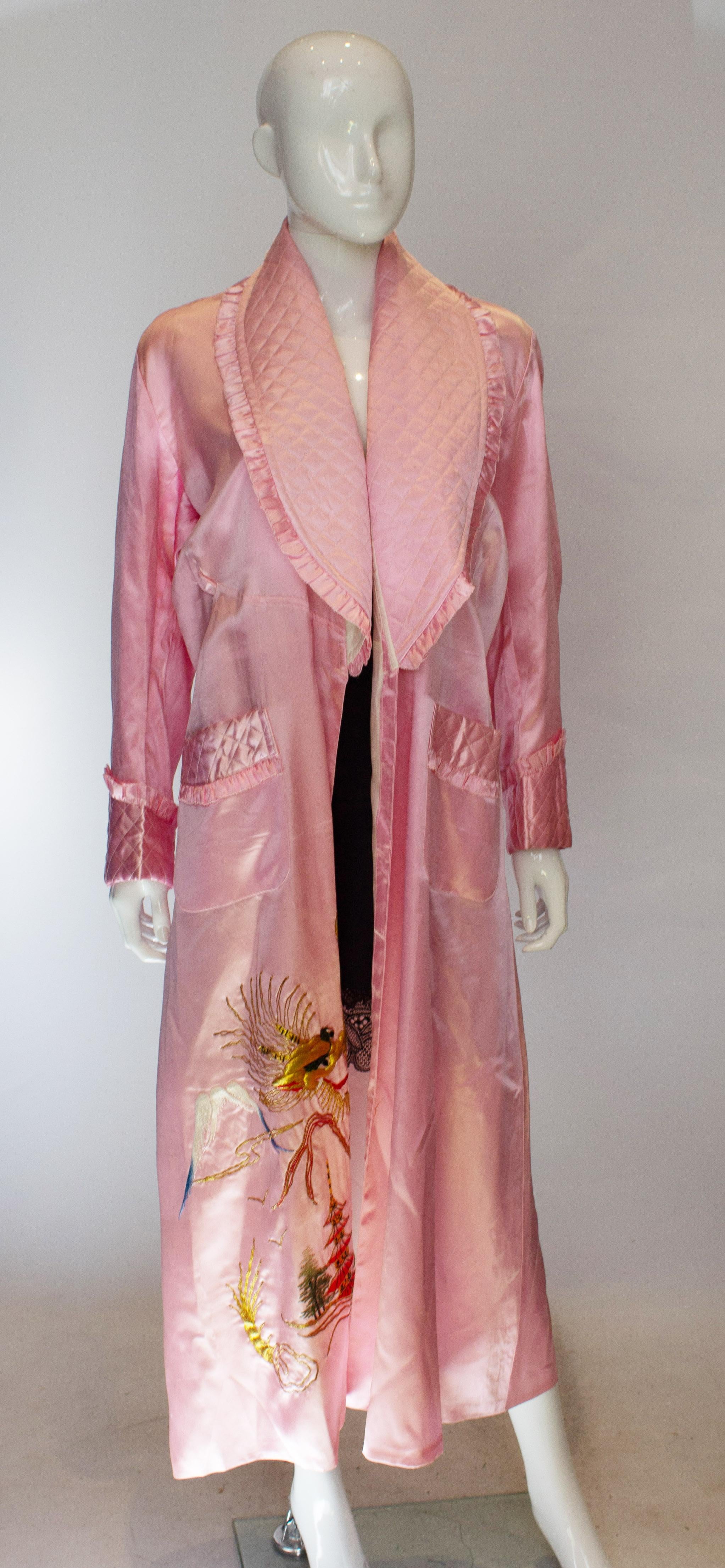 A pretty pink vintage robe with a quilted frilled shawl collar and two quilted pockets. The robe is lined and has embroidery detail.Measurements bust up to 41'',length 52''