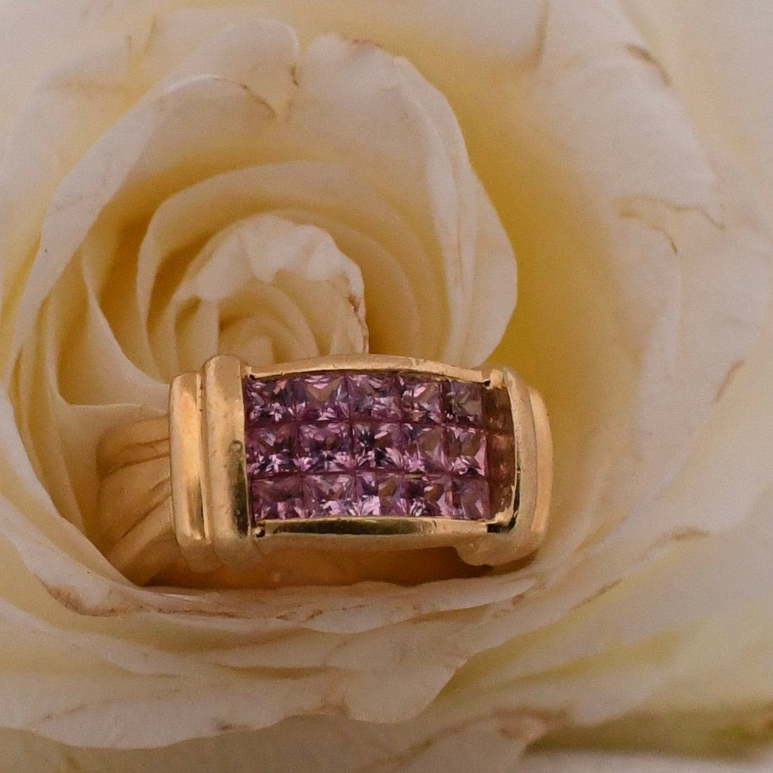 This exceptional gem is an absolute beauty. Artfully crafted in 18K yellow gold, its vibrant hue effortlessly catches the eye. At the heart of the column-like design lies a set of princess-cut pink sapphires, perfectly fitted together like tongue