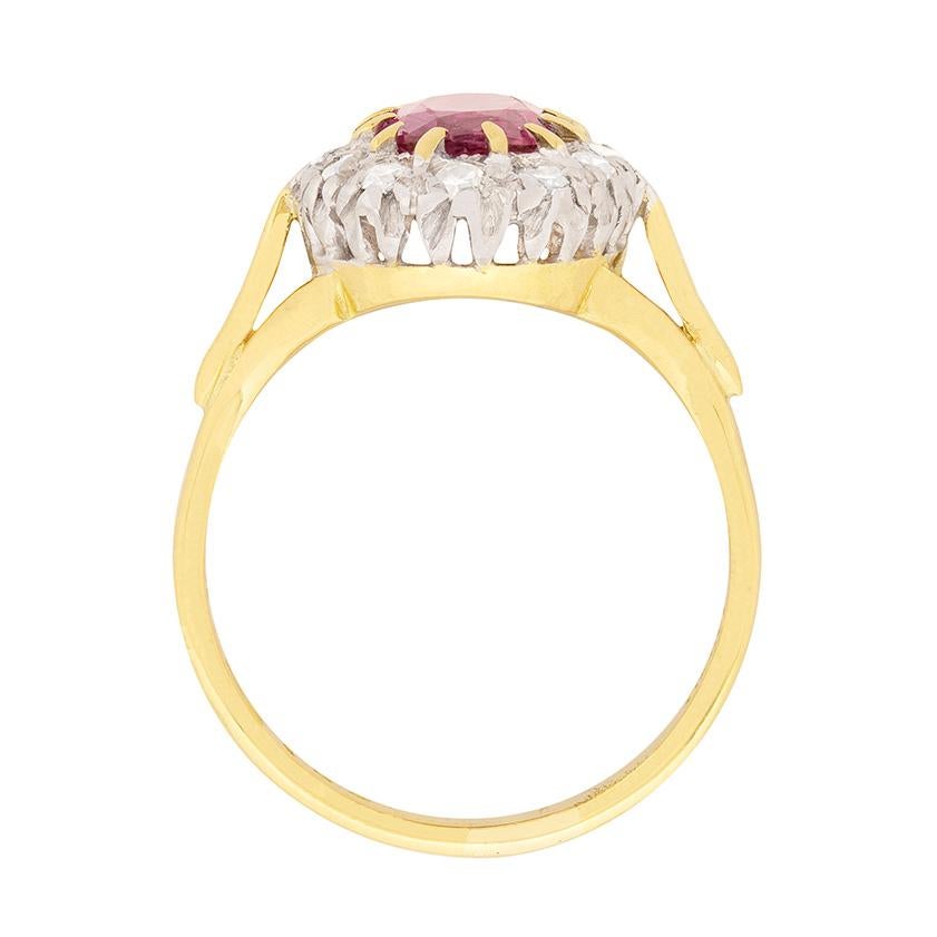 This dress ring dates back to the 1960s and features a stunning pink sapphire in the centre. The gemstone is heat treated and weighs 1.50 carat. It has been claw set using 18 carat yellow gold claws and the surrounding halo of diamonds has been set