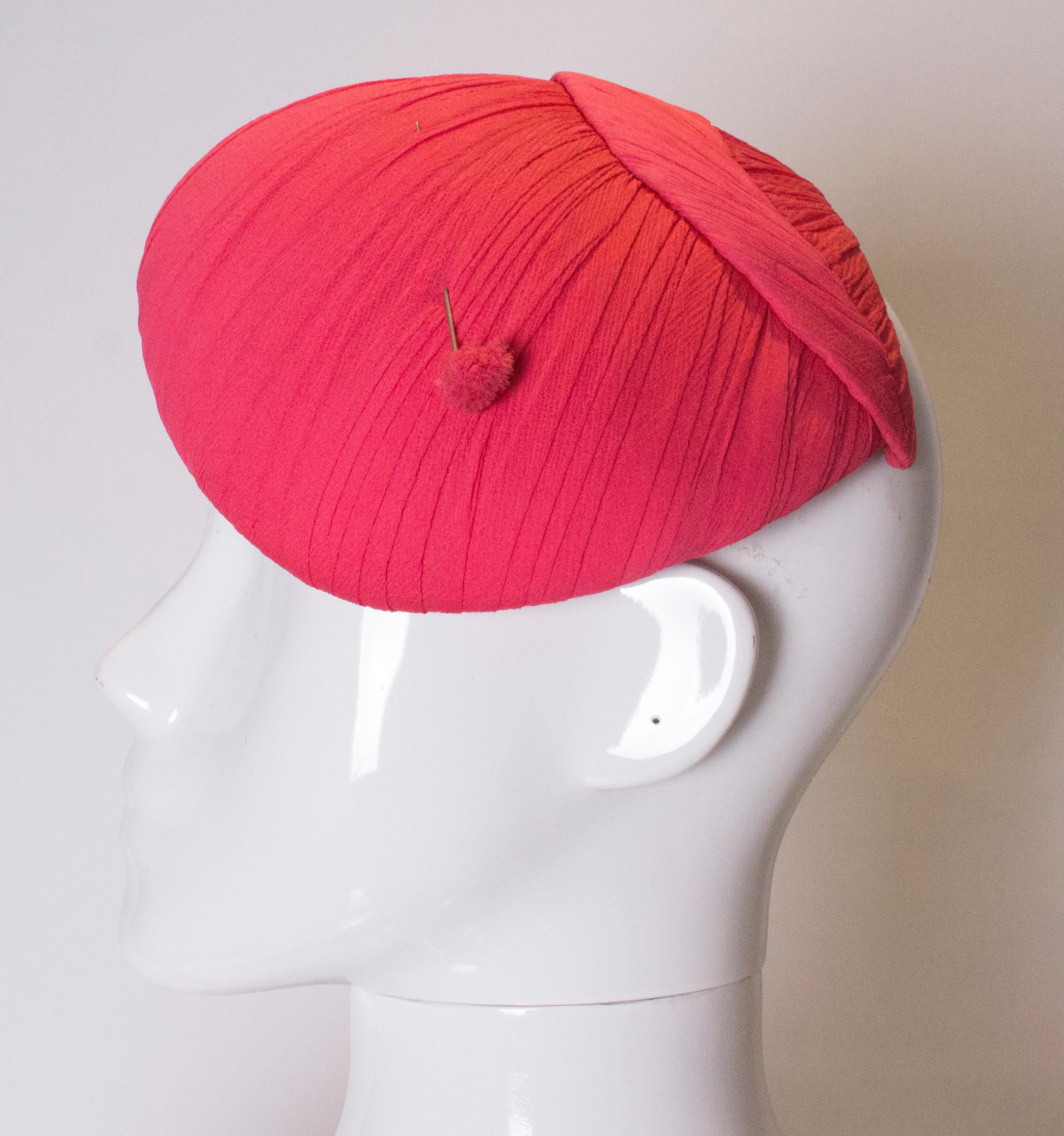 
A cute pink vintage hat. The hat is an interesting shape and is covered in various panels on pleated pink silk . It has the two original, and matching hat pins.