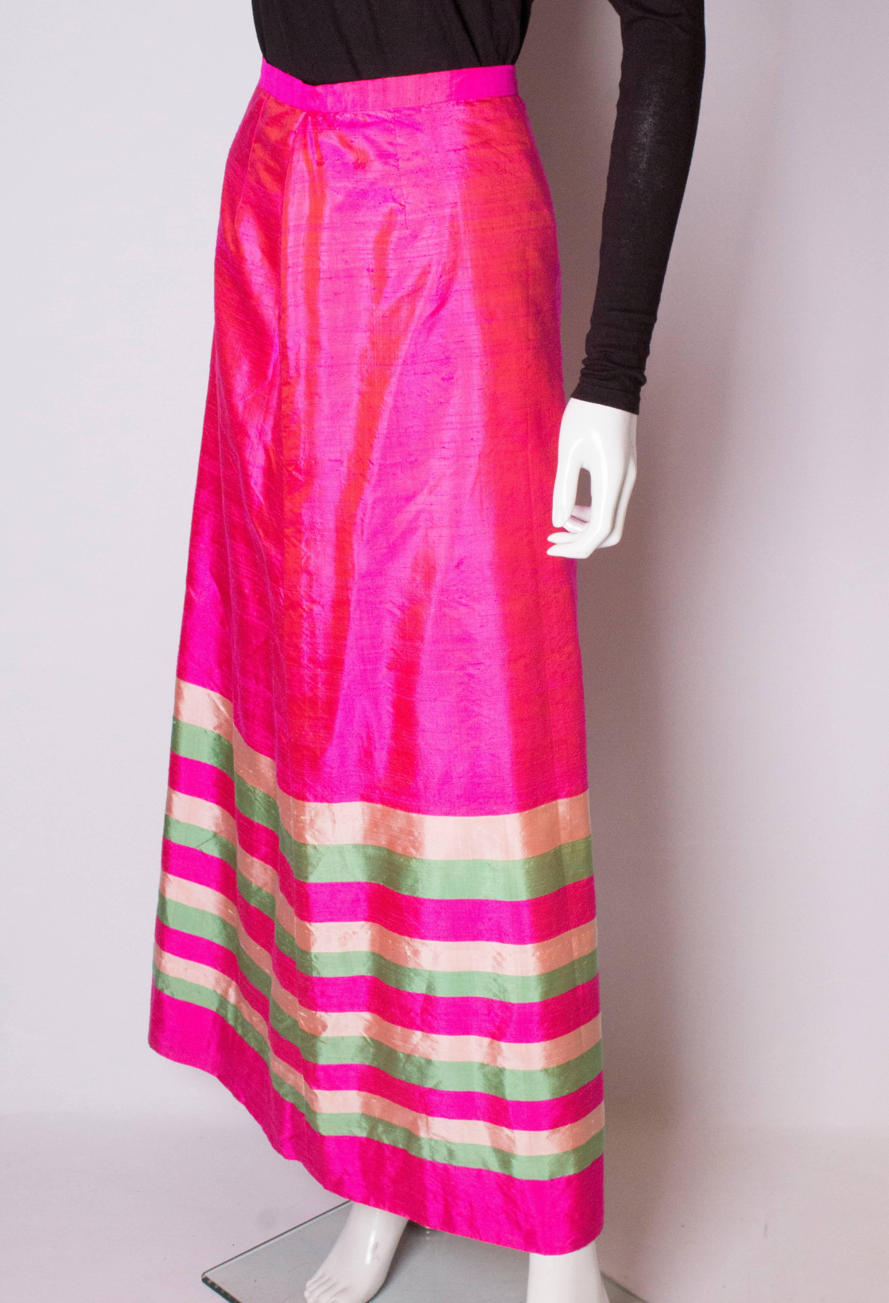 Une superbe jupe vintage en soie rose avec de la crème  et des rayures horizontales vertes à l'ourlet. La jupe est entièrement doublée et comporte une fermeture éclair centrale au dos.