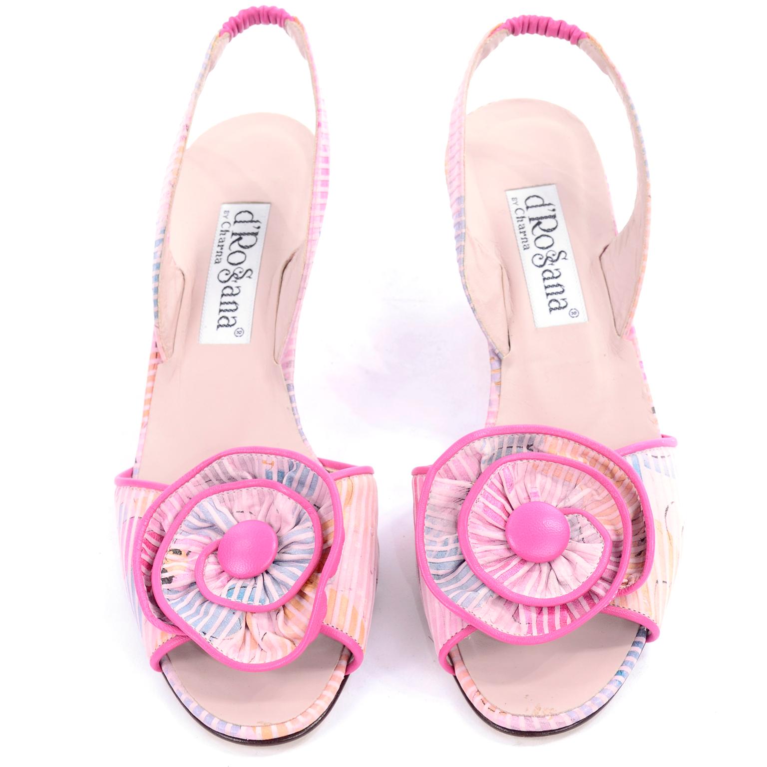 These are wonderful striped floral pink slingbacks by d'Rossana by Charna from the 1980's. The shoes have a large flower rosette trimmed in pink leather. There is a small wedge heel and they were worn only once. These open toe shoes have a leather