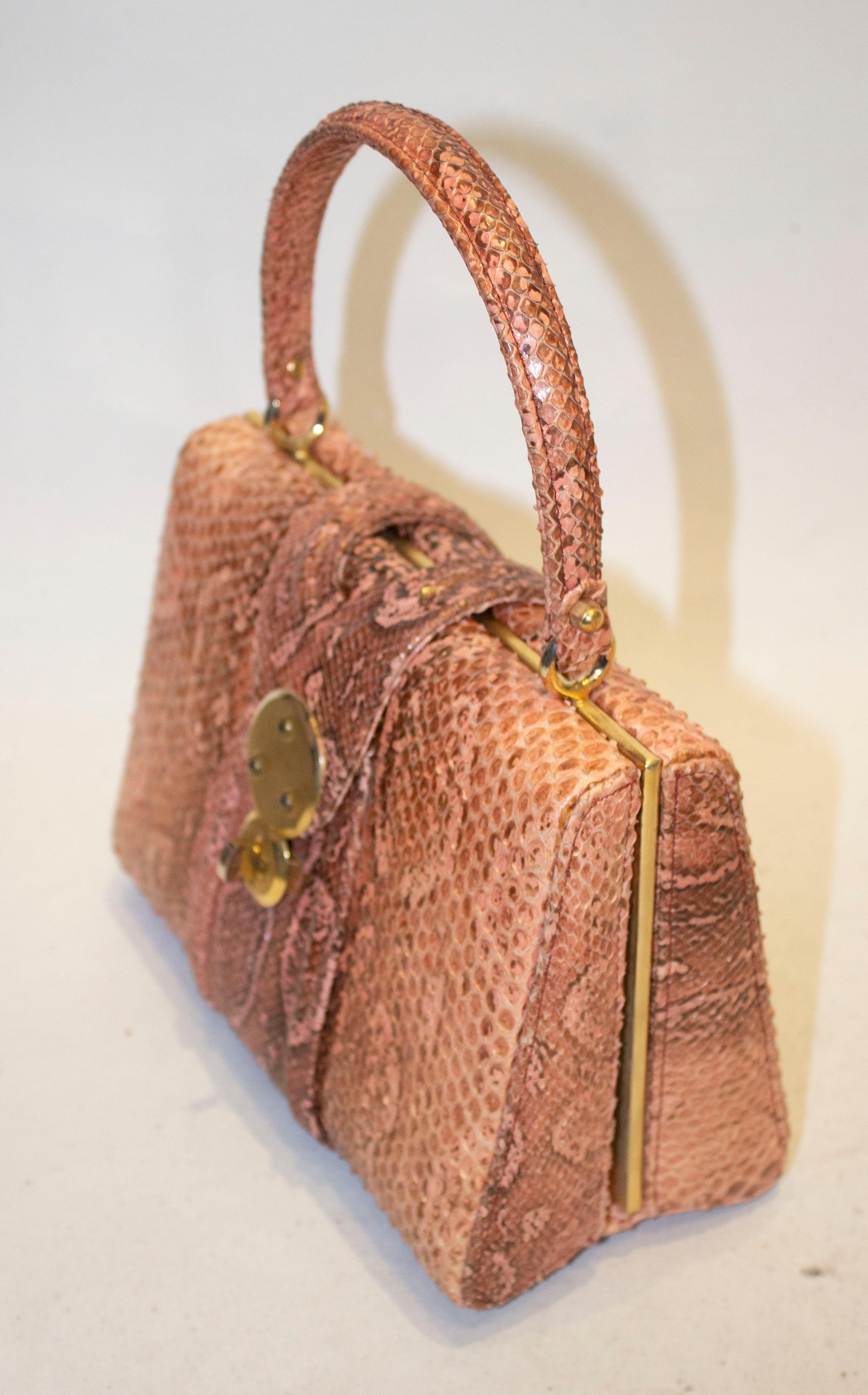 A wonderful vintage snakeskin handbag.  This bag is not only a beautiful colour but large enough for todays essentials.  It has a flap over opening with a clasp, and inside there are two compartments, one with a puc9k pocket and one with a zip