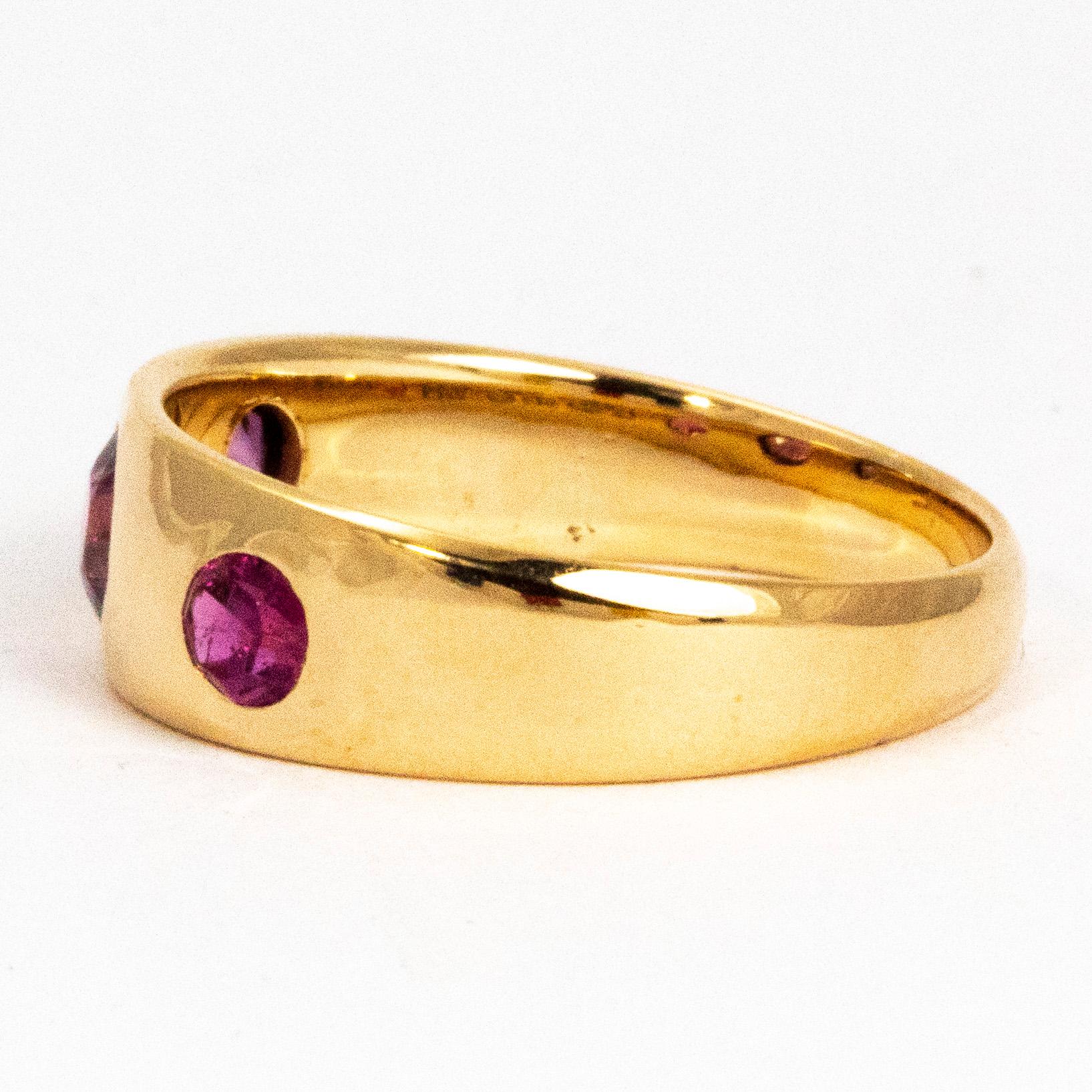 The three tourmaline stones that are set in this ring have a wonderful deep pink colour  and the 18 carat gold is beautifully glossy. The stones are sat perfectly flush within the gold band which give a clean silhouette to the ring. The centre stone