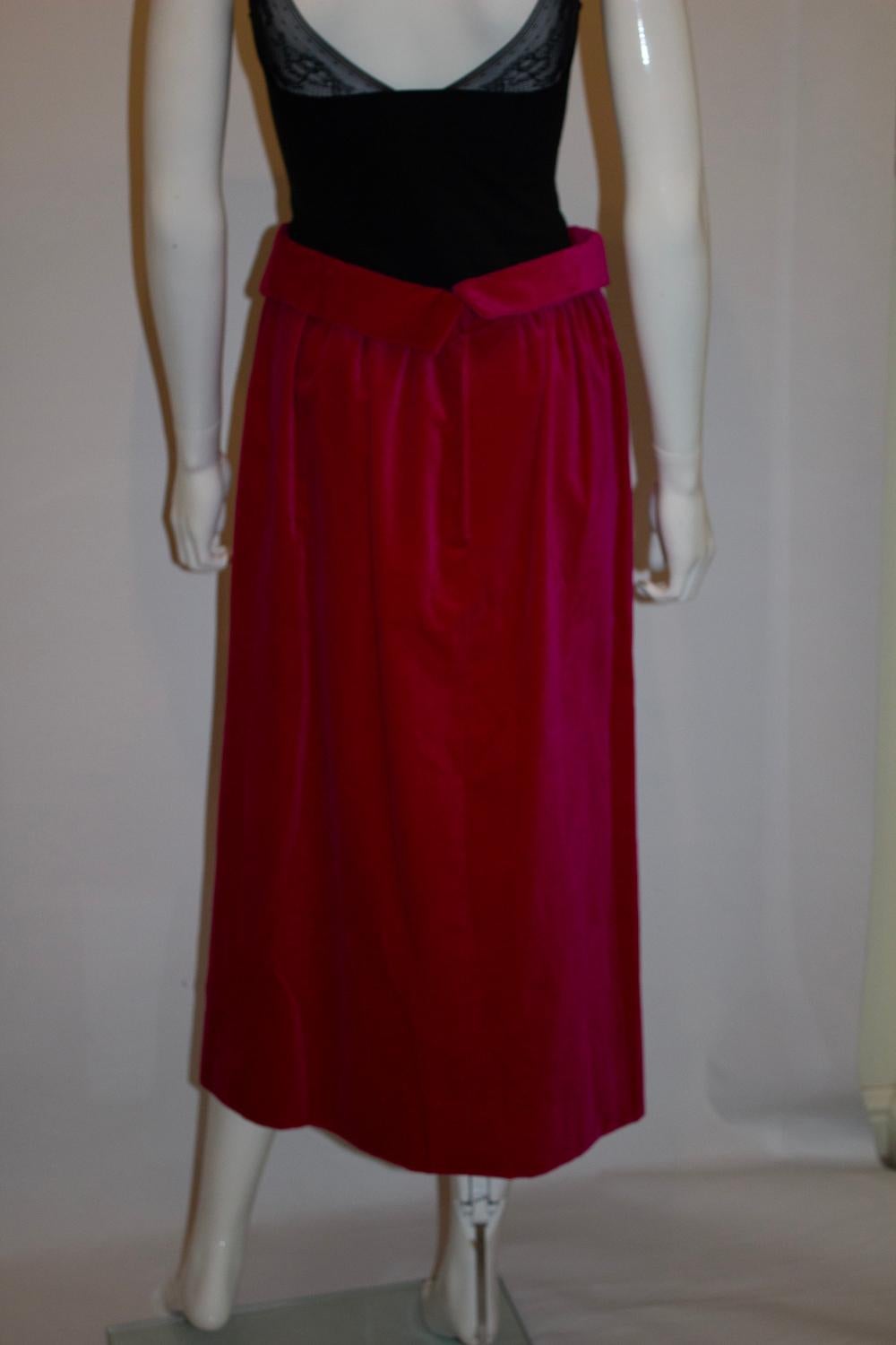 Una divertente gonna vintage per le giornate estive più fresche. In un grazioso velluto rosa, la gonna ha  un interessante giro vita e un'arricciatura. È completamente foderato e ha un'apertura a zip.
Misure: Vita 25'' , lunghezza 31''
