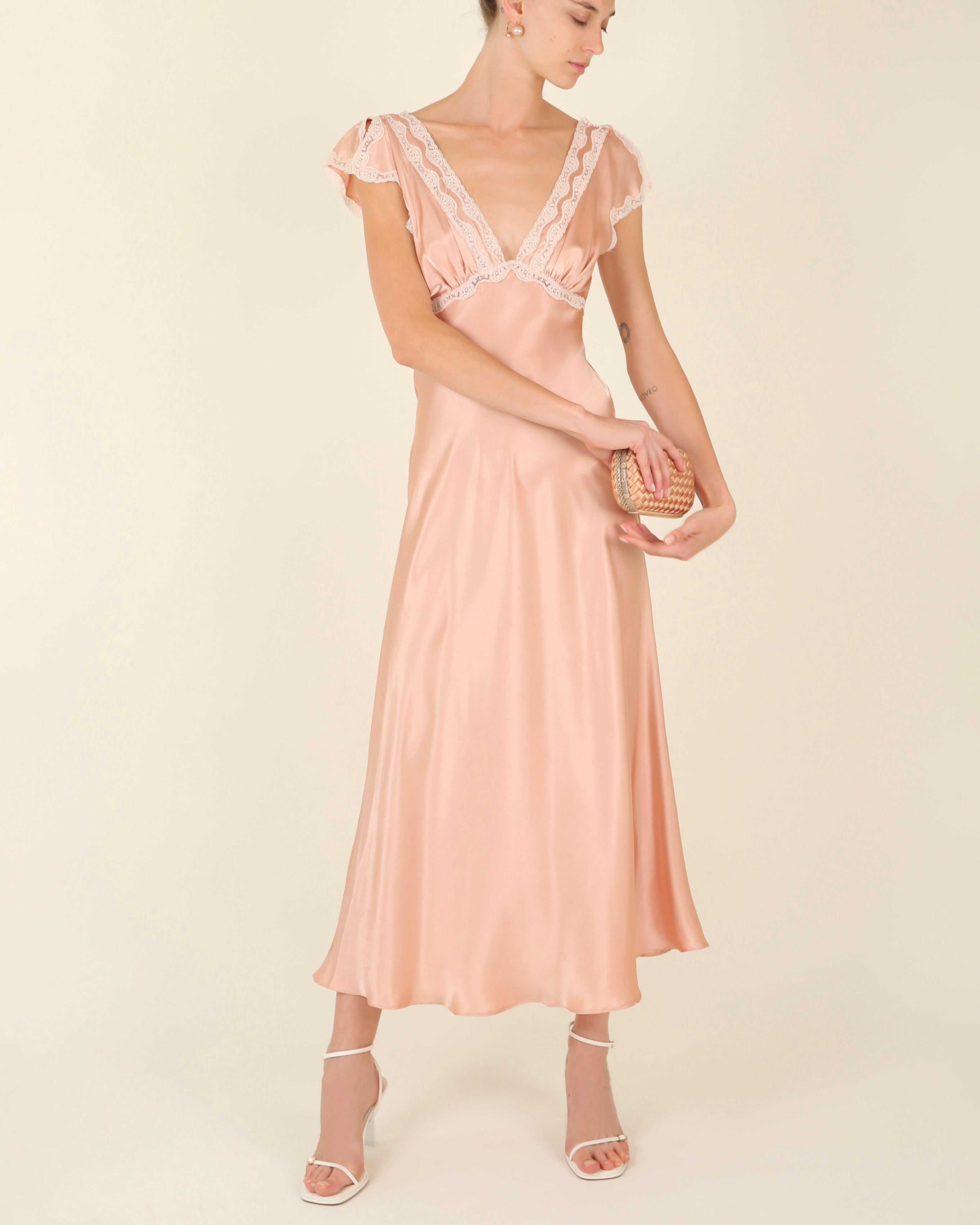 LOVE LALI Vintage

A very pretty vintage night gown in pink silk with white lace trim. Could easily be worn as a dress in an evening. Slitted flutter sleeves. A low cut V plunging neckline. Empire cut with a flowing skirt. An open low cut back. Midi