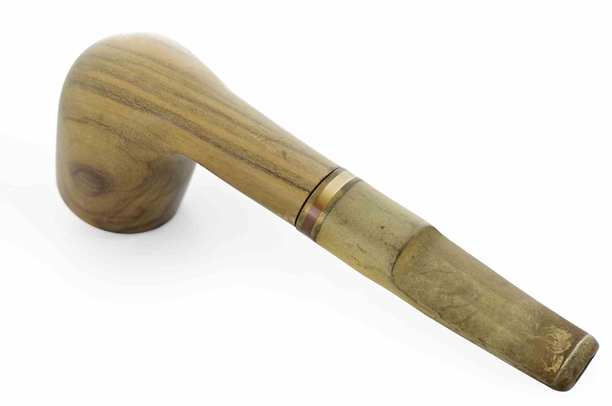 Pipa da fumo realizzata a mano con ciotola e gambo in legno di colore chiaro, quasi miele. A differenza delle pipe in radica più scure e tradizionali, qui il legno presenta venature naturali morbide e fluide, che gli conferiscono un fascino organico