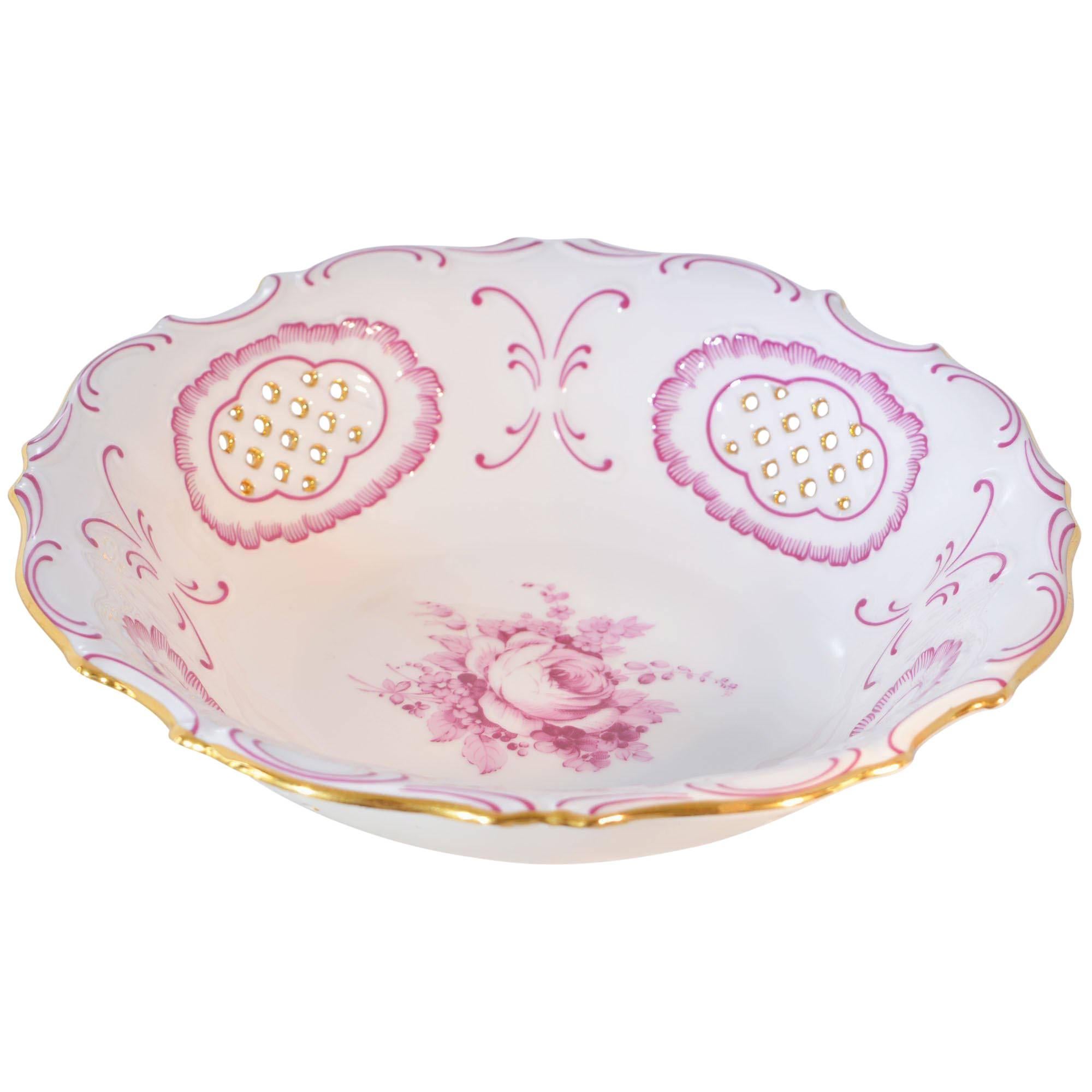 A vintage Pirken-Hammer porcelain bowl. This piece is decorated with a central pink floral design with reticulated panels to border accented in gilt and pink scalloped frames. The rim is trimmed in pink scrollwork and finished in gold trim. It is