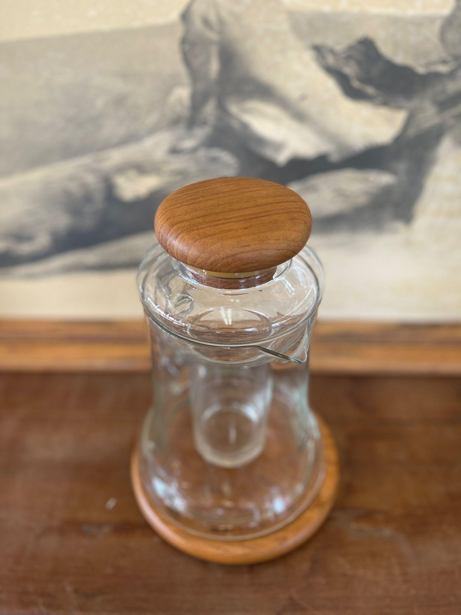 Pitcher is Glass or Similar Material. Teak Base and Lid have Makers Sticker as Pictured. Inner Layer of Pitcher can be Used to Fill with Ice to Keep Drinks Cold.

Dimensions. 8 Diameter; 11 H