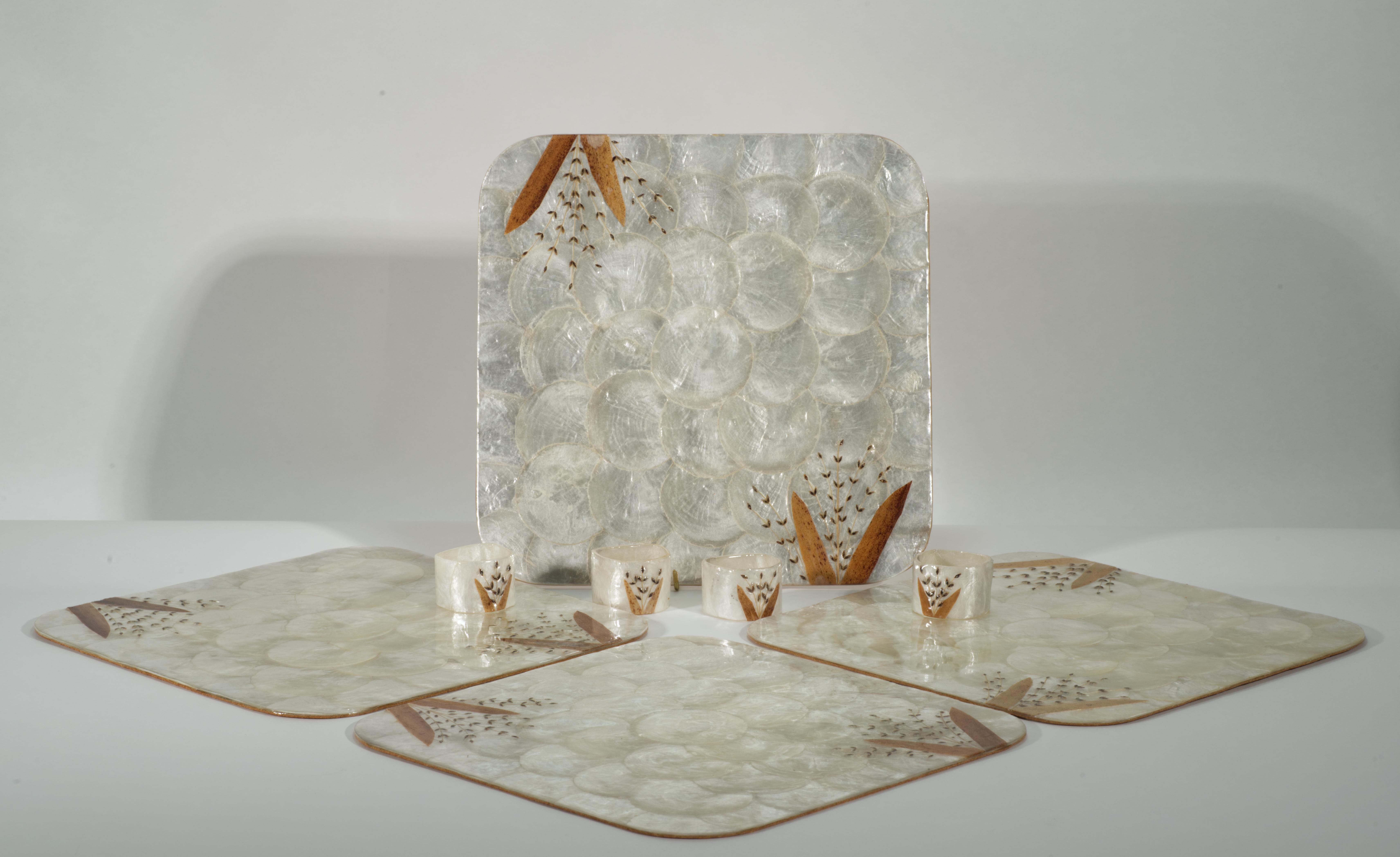 Vintage-Set von Tischsets und Serviettenhaltern mit Capiz-, Abalone- und Perlmuttmuschel-Motiven mit überlappendem Muschelmuster, die rechteckige Tischsets bedecken. Sowohl die Tischsets als auch die Serviettenringe weisen abstrakte Blumendekore in