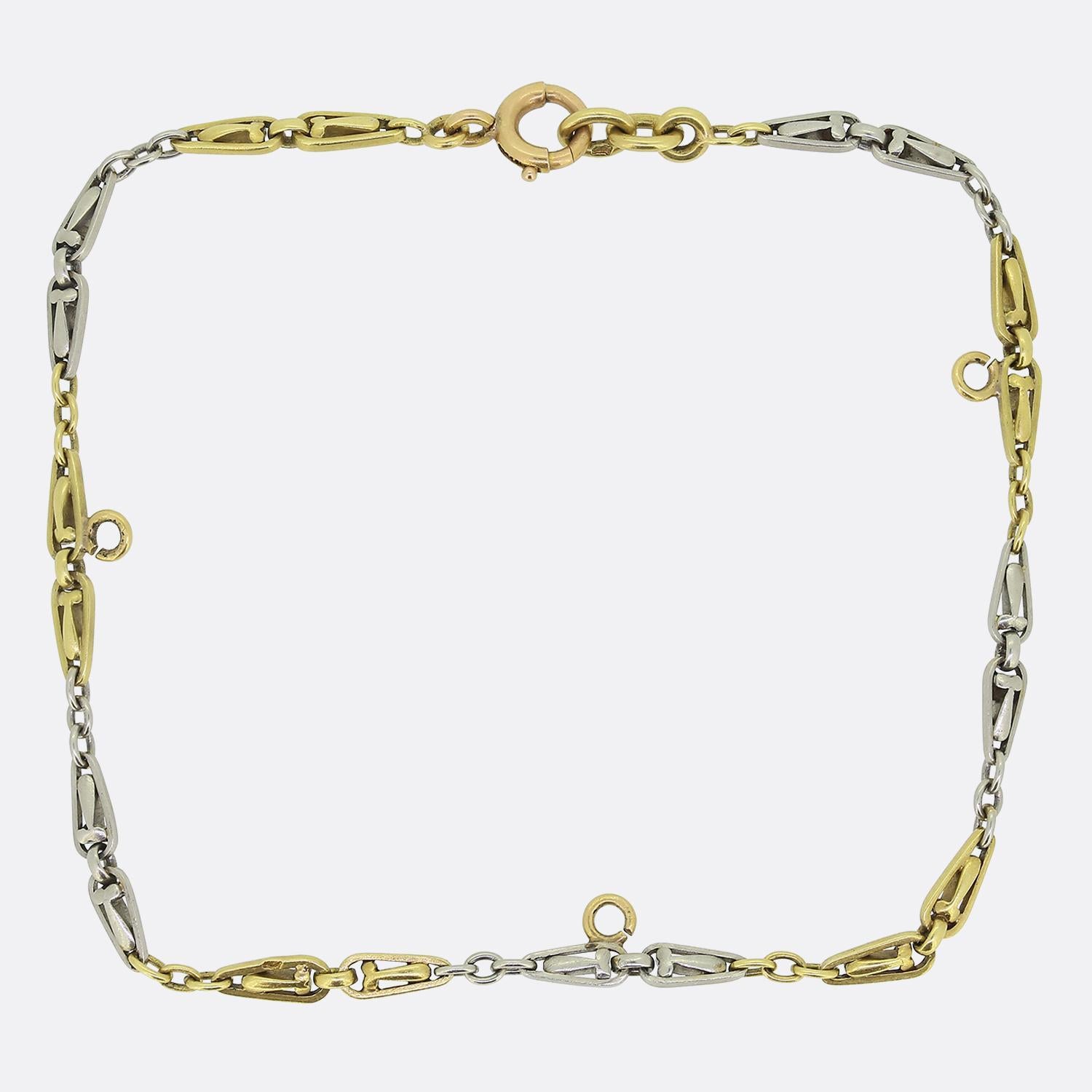 Here we have a lovely vintage charm bracelet. This (currently plain) piece is comprised of ornate matching fancy links in both platinum and a rich 18ct yellow gold. Each yellow gold link posses a jump ring on the outside freely available for the