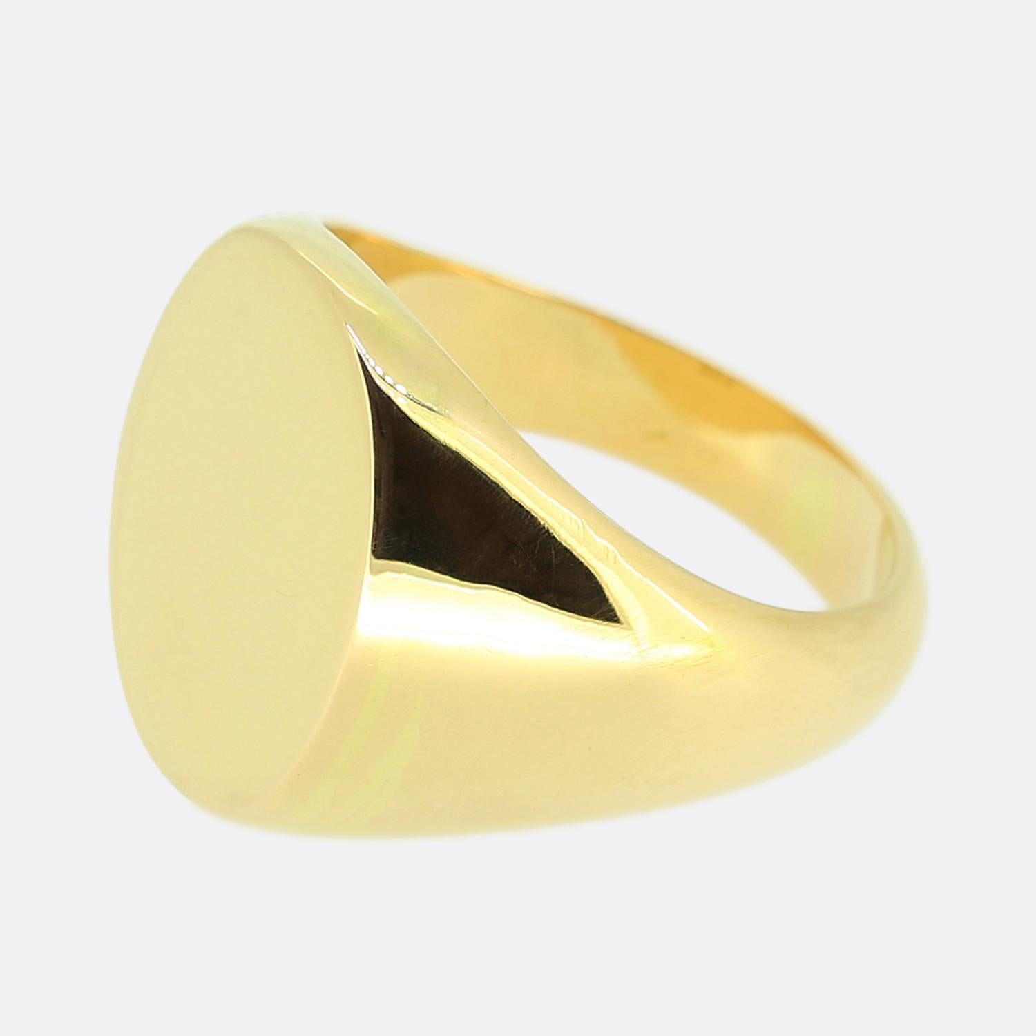 Ecco un anello con sigillo in stile classico realizzato in oro giallo 18ct. L'anello è caratterizzato da una faccia ovale liscia e lucida, che offre un design elegante e minimalista. L'ampia fascia si assottiglia dolcemente verso la parte
