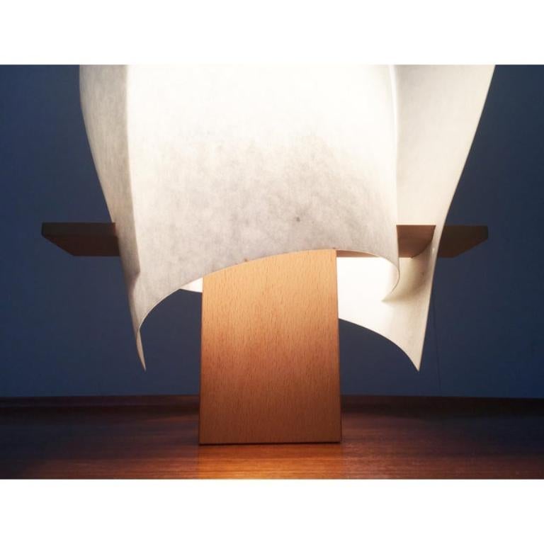 Lampe de table du célèbre fabricant Domus d'après un design d'Iris Kremer datant de la fin des années 90.

La lampe convainc par sa matérialité et son langage sculptural. La base est constituée d'un simple bloc de bois de hêtre. Sur la base se