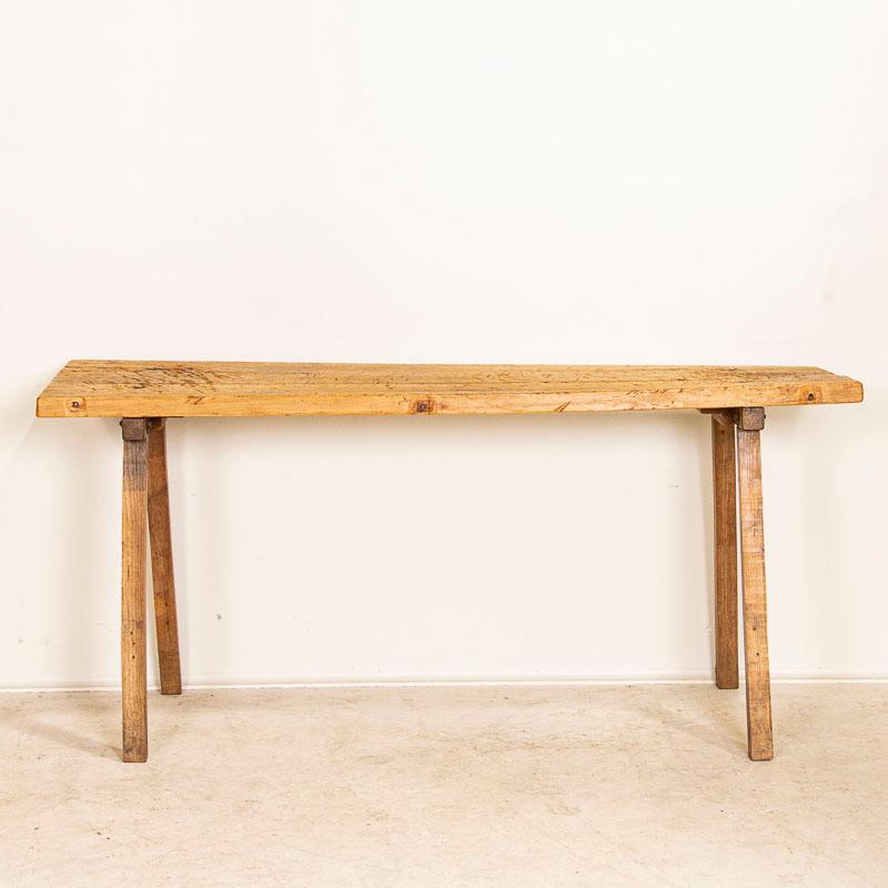 There is a beauty to the wood that was used to create this old work table which now serves as a modern day console table. Examine the close up photos to appreciate the patina in the 3 planks that comprise the top. Note the deep gouges, scrapes,