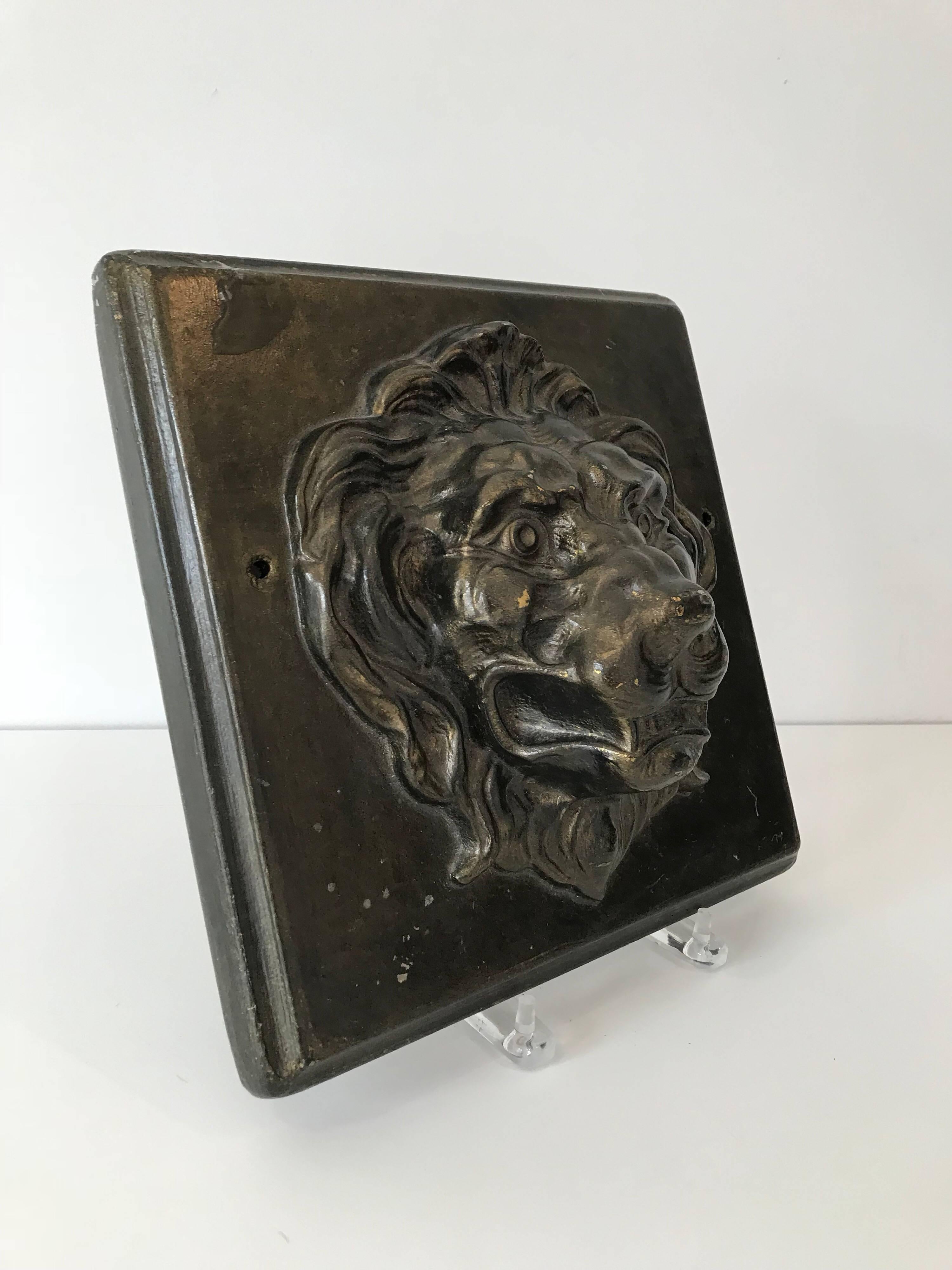 A vintage early 20th century plaster plaque of a lion with a bronze toned finish.