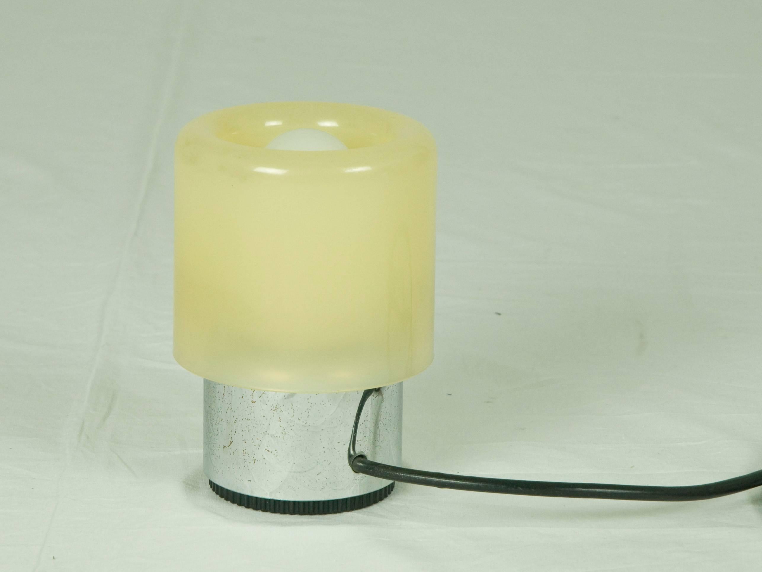 This small table lamp was produced by Kartell, Italy in 1971. The lamp is made from a chromed ABS plastic base and a polypropylene shade. Thanks to its internal switch, you can switch on/off the light by a single pressure. The lamp remains in a good