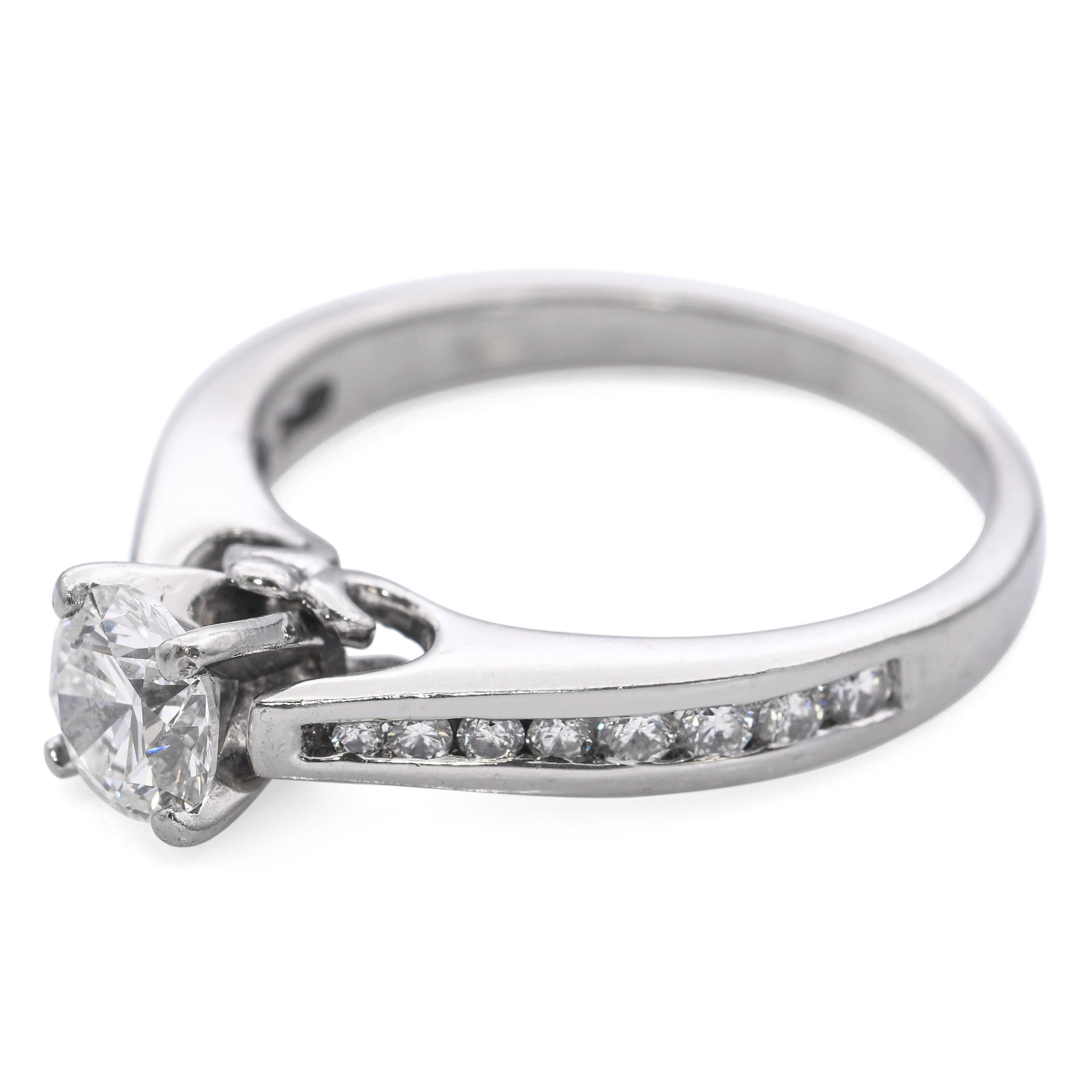 Cette bague de fiançailles vintage est fabriquée en platine luxueux et comporte un total de 0,98 carats de diamants éblouissants. Au centre se trouve un diamant brillant, accentué par de plus petites pierres le long de la bande pour plus d'éclat et