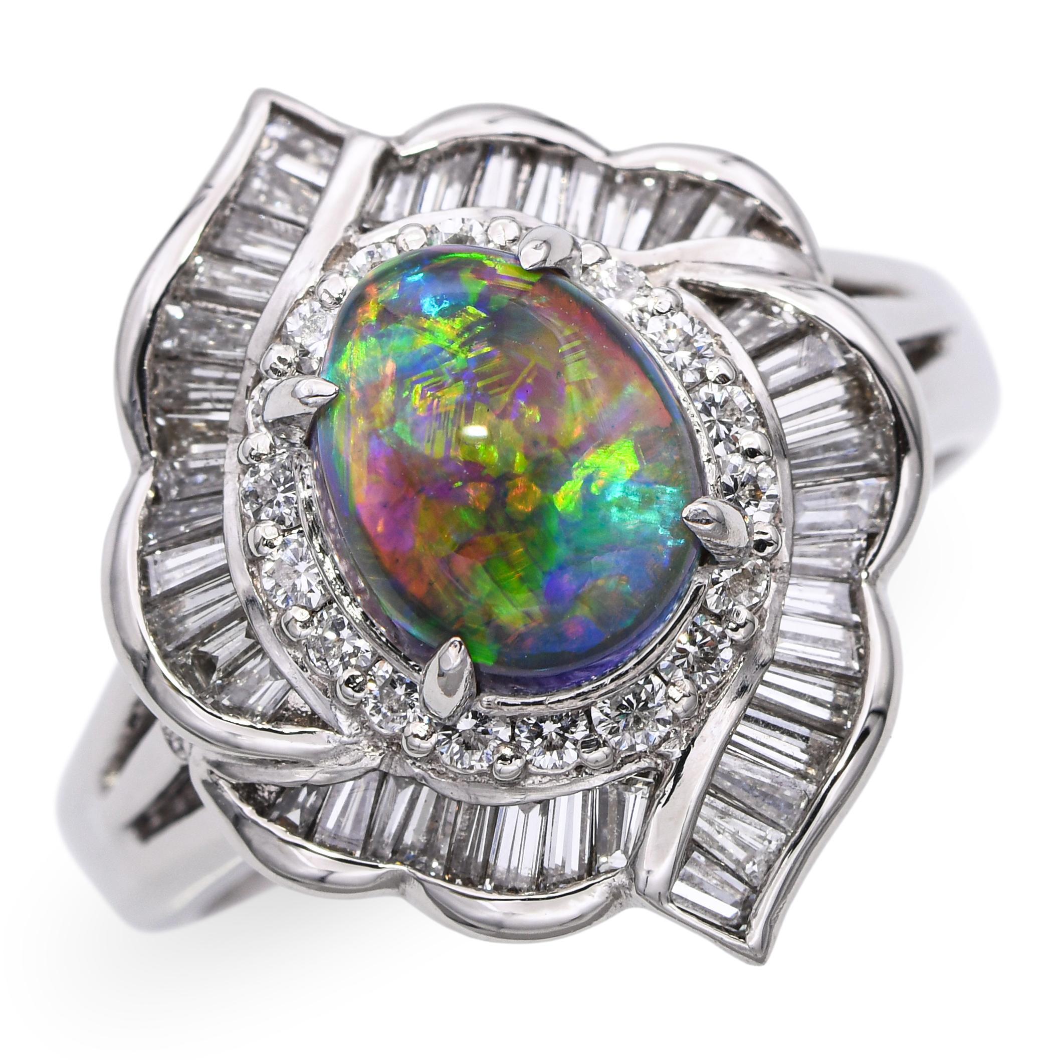 Questo anello vintage in platino mette in mostra un'ipnotica opale di cristallo nero B4 da 1,15 carati, che irradia lampi di blu profondo, verde e viola con un accattivante gioco di colori. L'opale è circondato da un'aureola di circa 0,79 carati