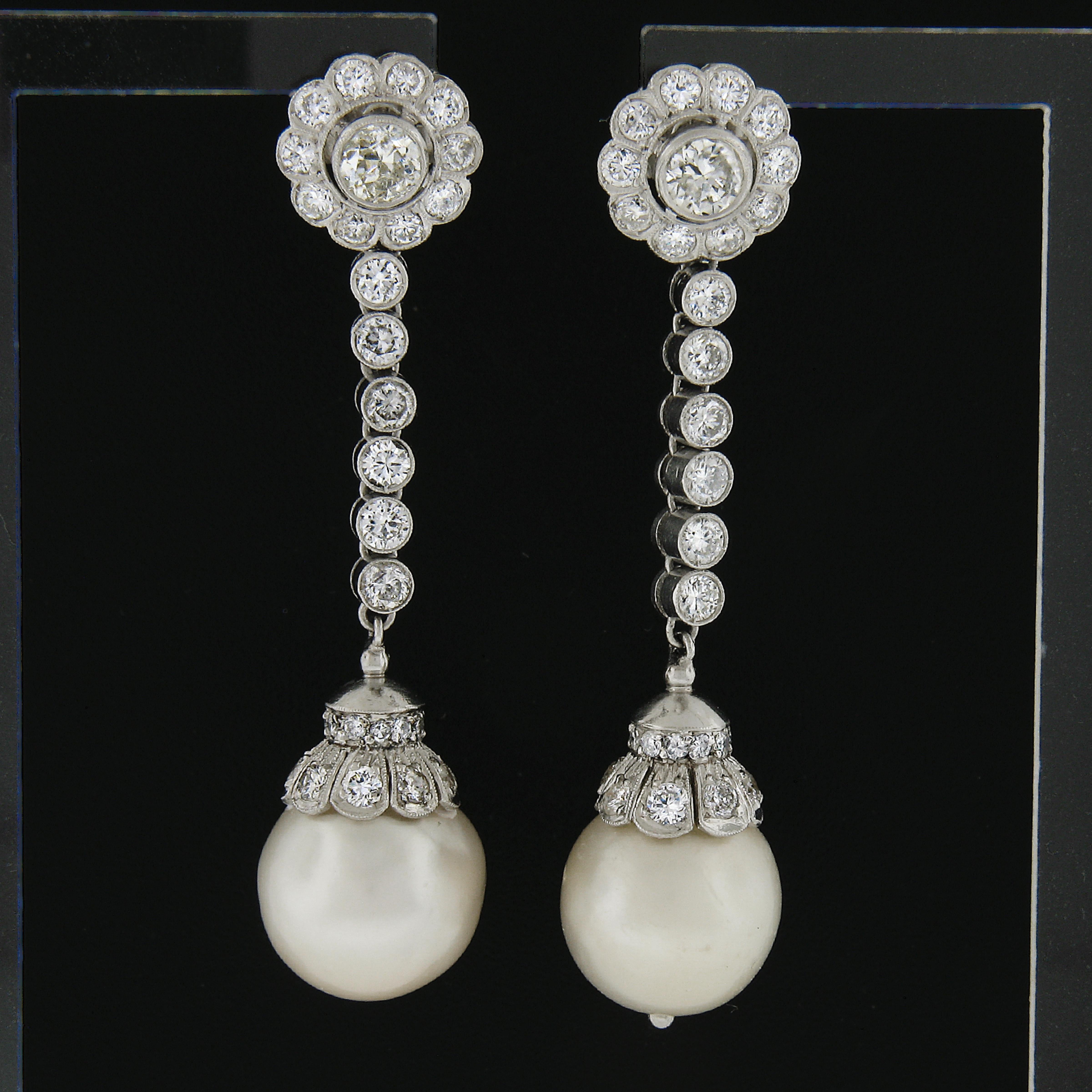 –Stone(s)–
(2) Cultured Pearls - Creamy White Color - 11.9mm each (approx.)
(2) Natural Genuine Diamonds - Round Brilliant Cut - Bezel Set - J/K Color - I1/I2 Clarity - 0.56ctw (approx.)
(70) Natural Genuine Diamonds - Round Brilliant Cut - Bezel &