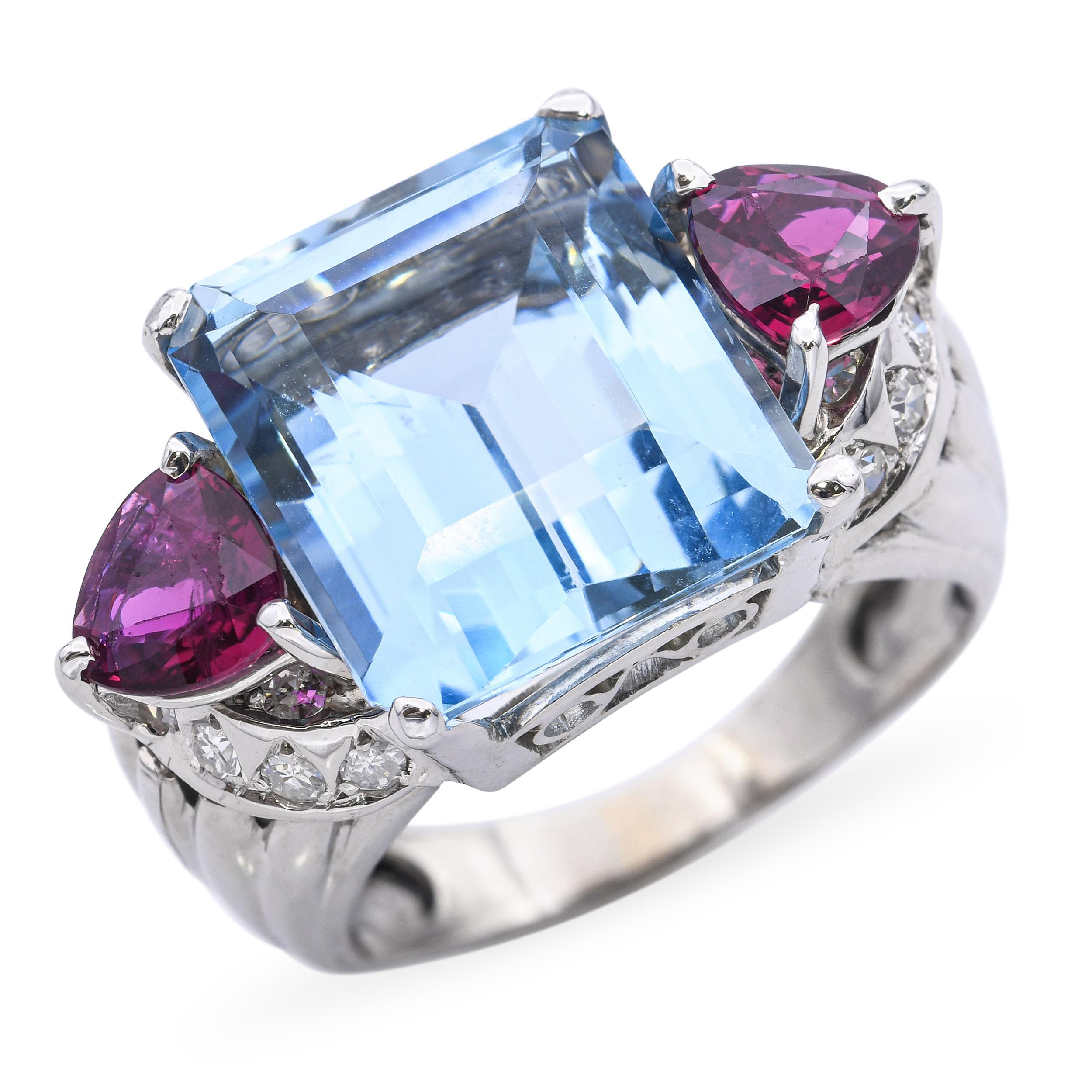 Questo sorprendente anello vintage è realizzato in lussuoso platino e mette in mostra una splendida acquamarina da 12,0ct come pezzo centrale. La gemma blu vibrante e ghiacciata è affiancata da 1,10 carati di rubini vividi, creando un contrasto di
