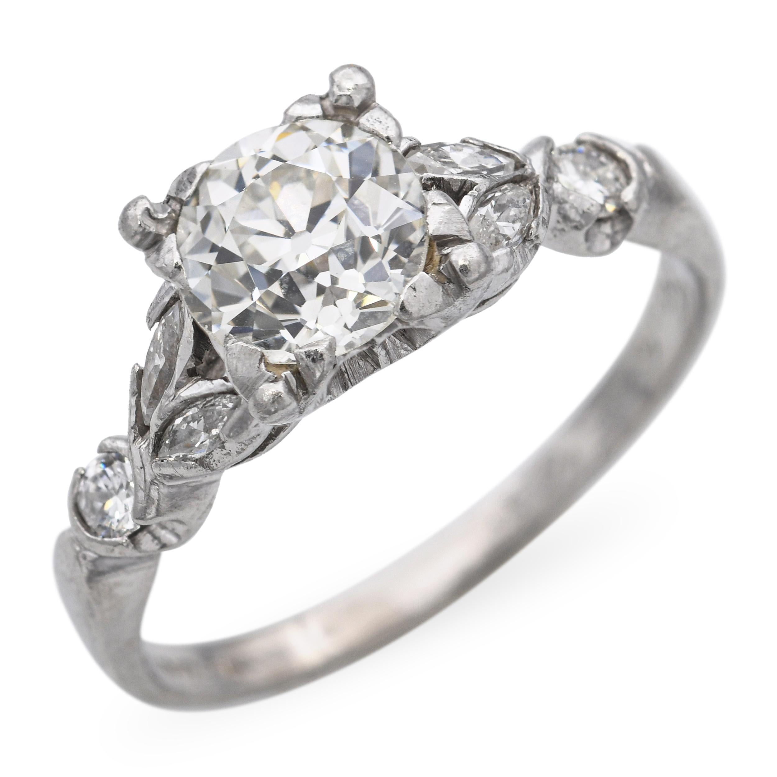 This sophisticated vintage engagement ring is crafted in platinum and features a total of 1.35 carats of sparkling diamonds arranged in an elegant motif design. The center diamond is complemented by smaller accent stones, creating a harmonious