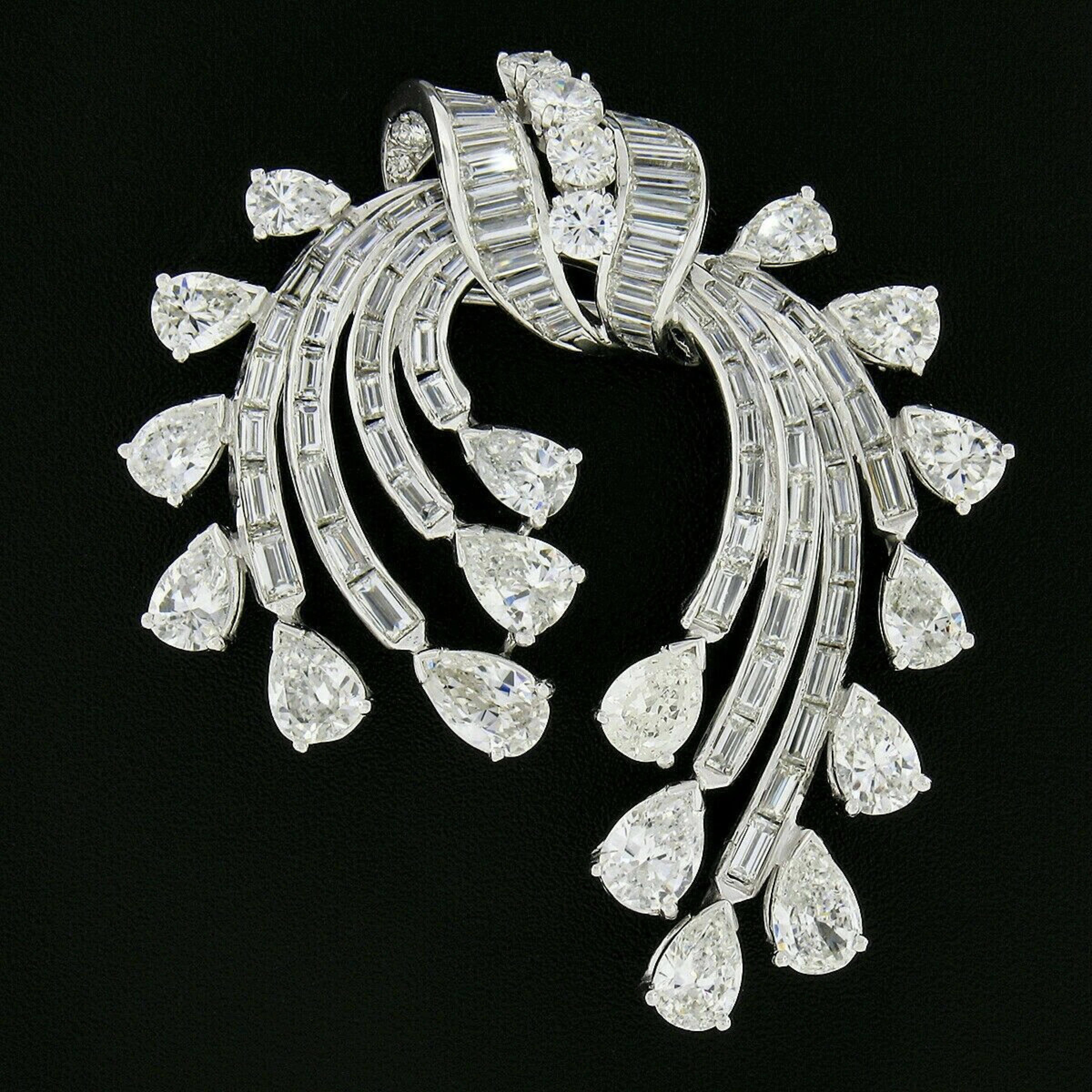 This is a truly jaw dropping vintage statement brooch or pendant that was crafted in platinum during the 1950s and is drenched with approximately 13.65 carats of very fine quality diamonds throughout. It features multiple branches of baguette