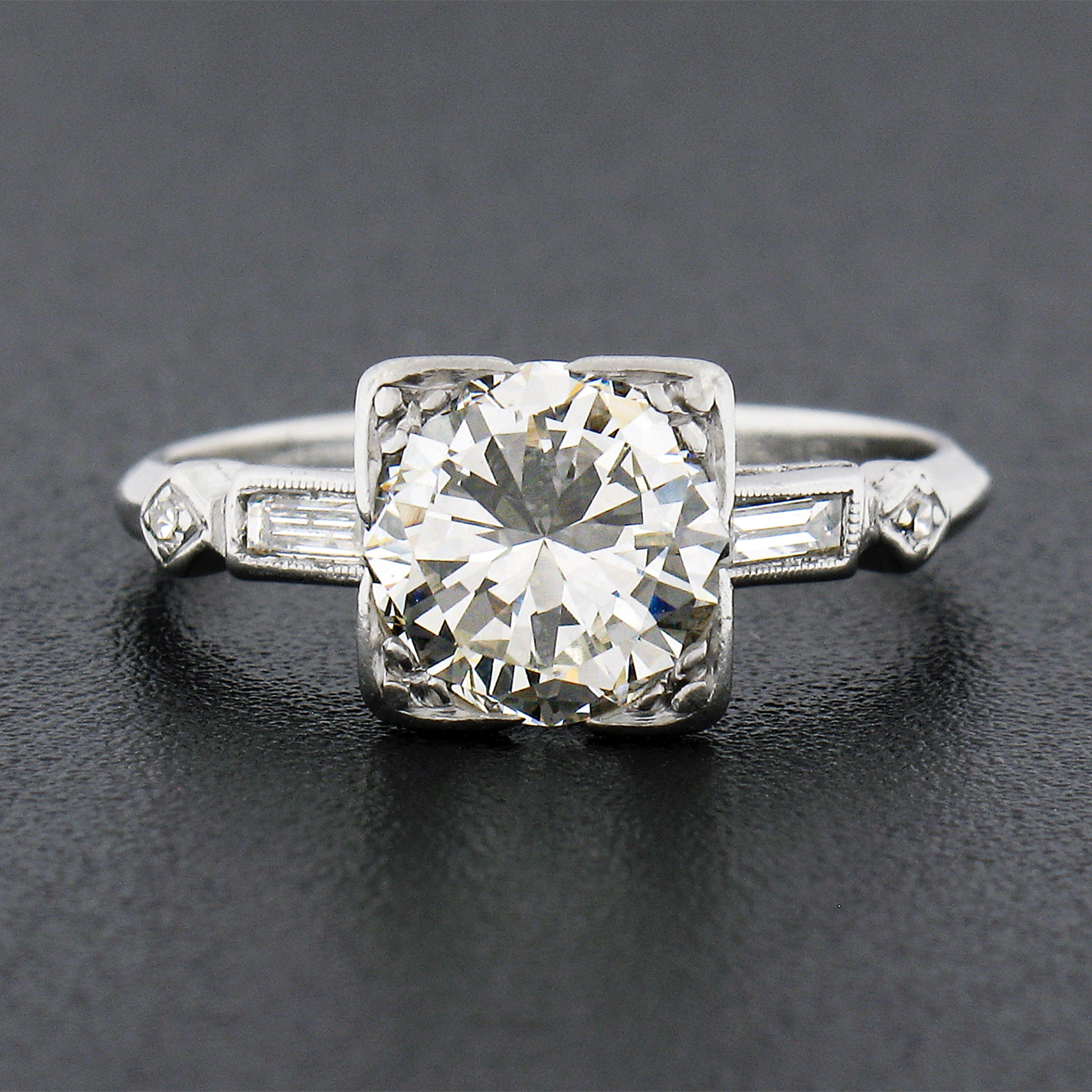 This gorgeous vintage diamond engagement ring was crafted from solid platinum during the 1940's. It features a stunning and super fiery old transitional cut diamond neatly pave set at the center of the squared open basket setting, displaying a very