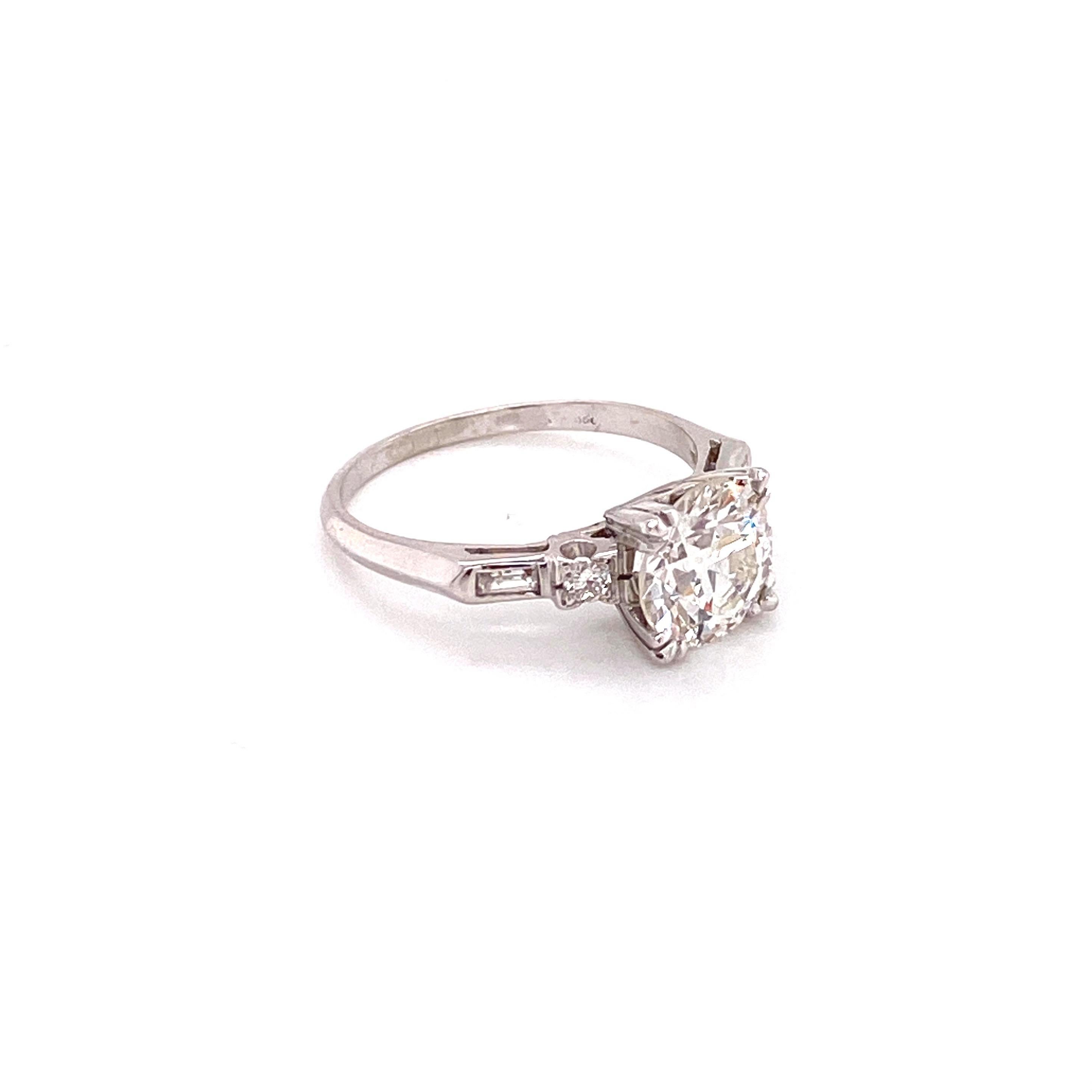Dieser atemberaubende Vintage-Verlobungsring aus den 1950er Jahren ist der Inbegriff eines Schmuckstücks aus einer berühmten Ära. Im Mittelpunkt steht ein prächtiger Diamant im europäischen Schliff von 1,90 Karat, der mit seiner warmen Antik-I-Farbe