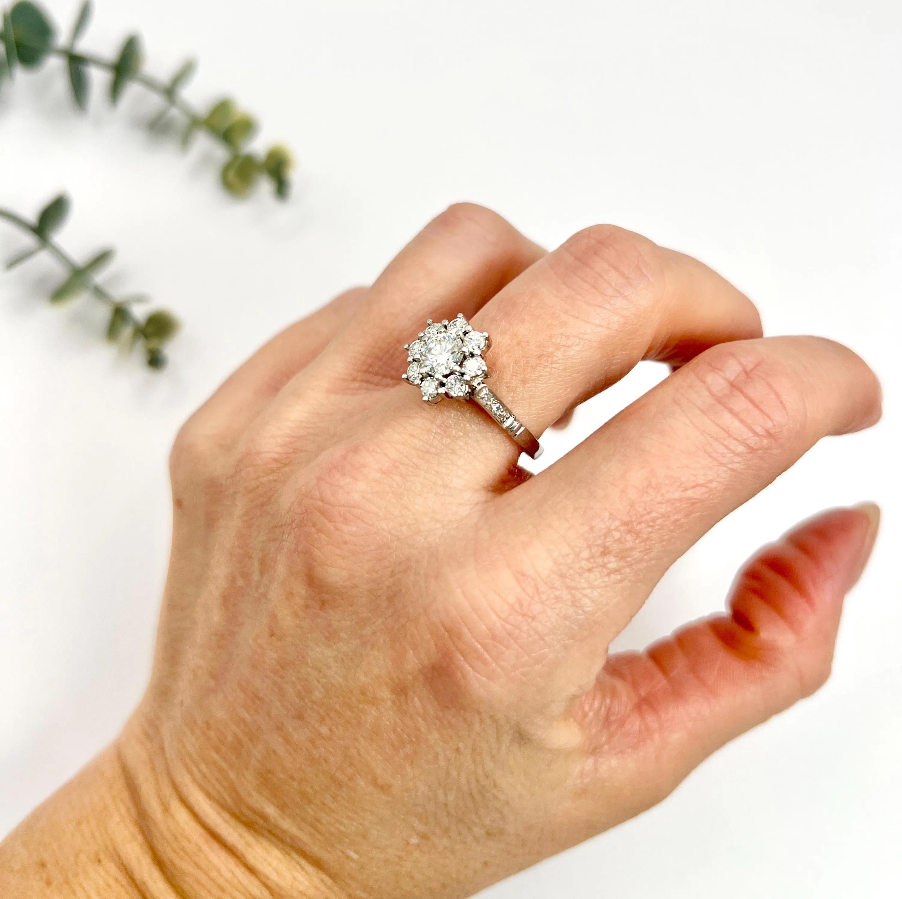 Vintage Diamond Daisy Ring 

Platinum Tested

Circa 1980s

Experience the elegance of the past with this exquisite vintage platinum daisy ring from the 1980s. This stunning piece features approximately 1.35 carats of natural, dazzling diamonds,