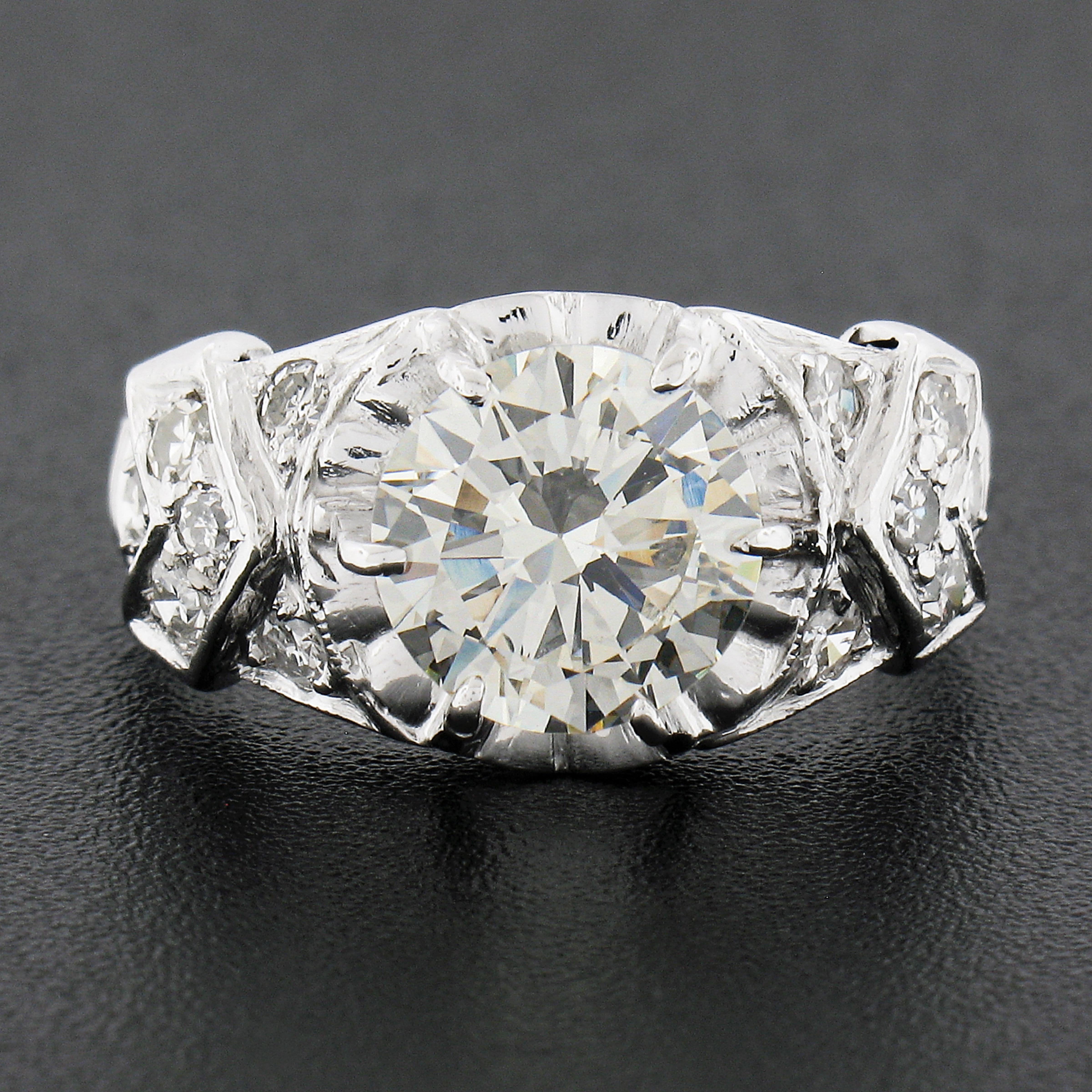 This is an absolutely jaw dropping vintage engagement ring that was crafted from solid platinum during the 1940's. It features a GIA certified, round brilliant cut, diamond neatly set at the center in a buttercup prong basket setting weighing