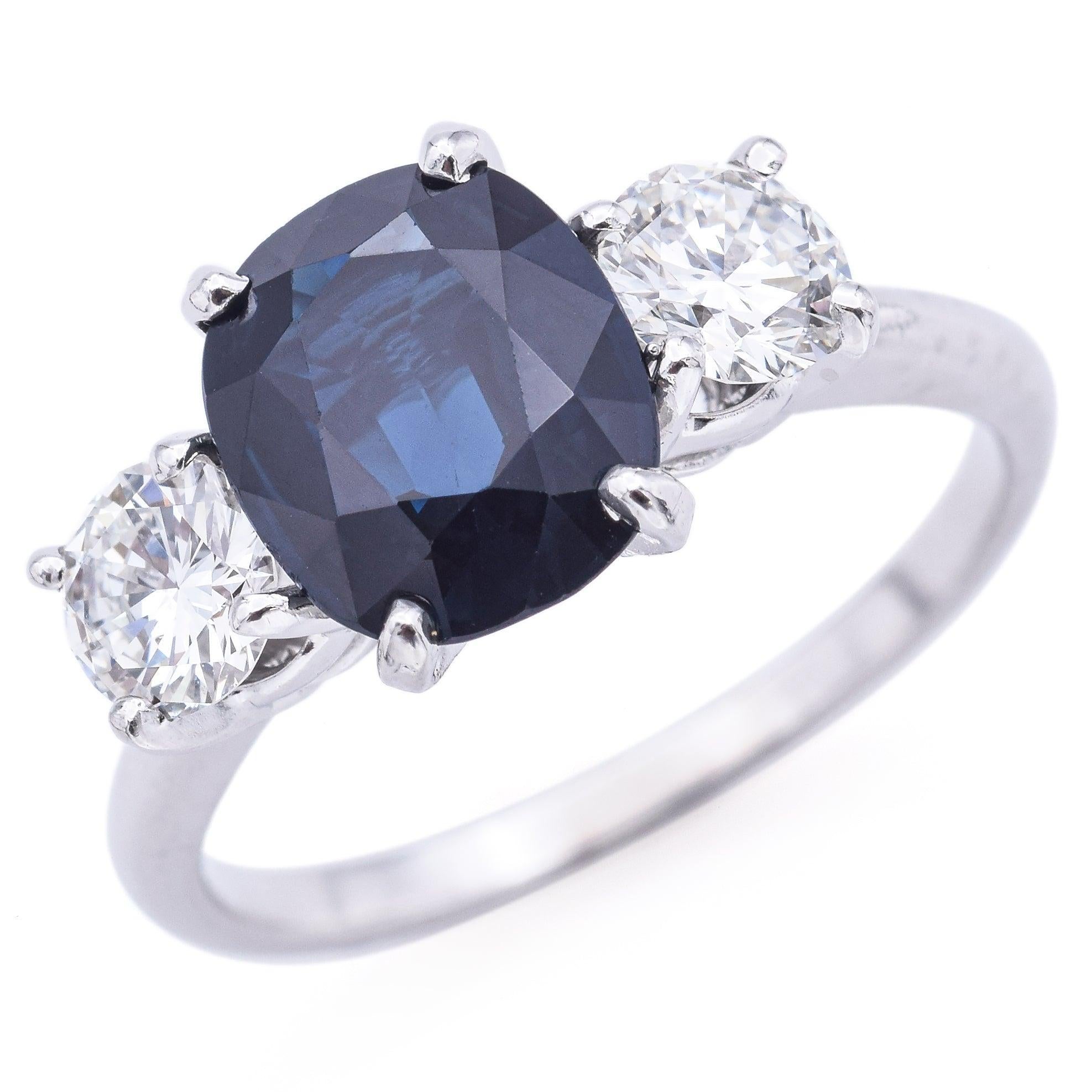 Un rico zafiro azul real de 2,71 qt corona este anillo vintage de tres piedras en platino, flanqueado por dos brillantes diamantes que suman 0,96 qt. El engaste de platino ofrece tanto resistencia como elegancia atemporal, resaltando el trío de