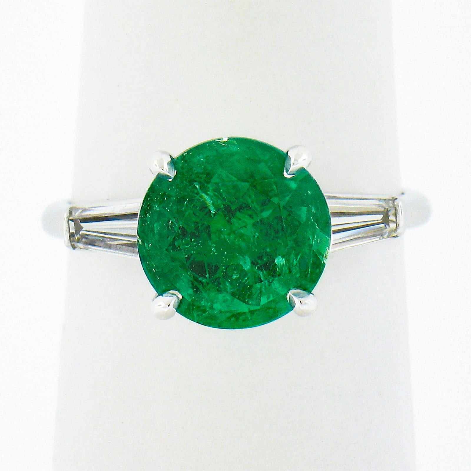 Here we have a magnificent vintage emerald and diamond ring that is crafted in solid platinum. The ring features a gorgeous, GIA certified, natural emerald stone that has a very rare round cut and displays a truly incredible brilliant and vivid