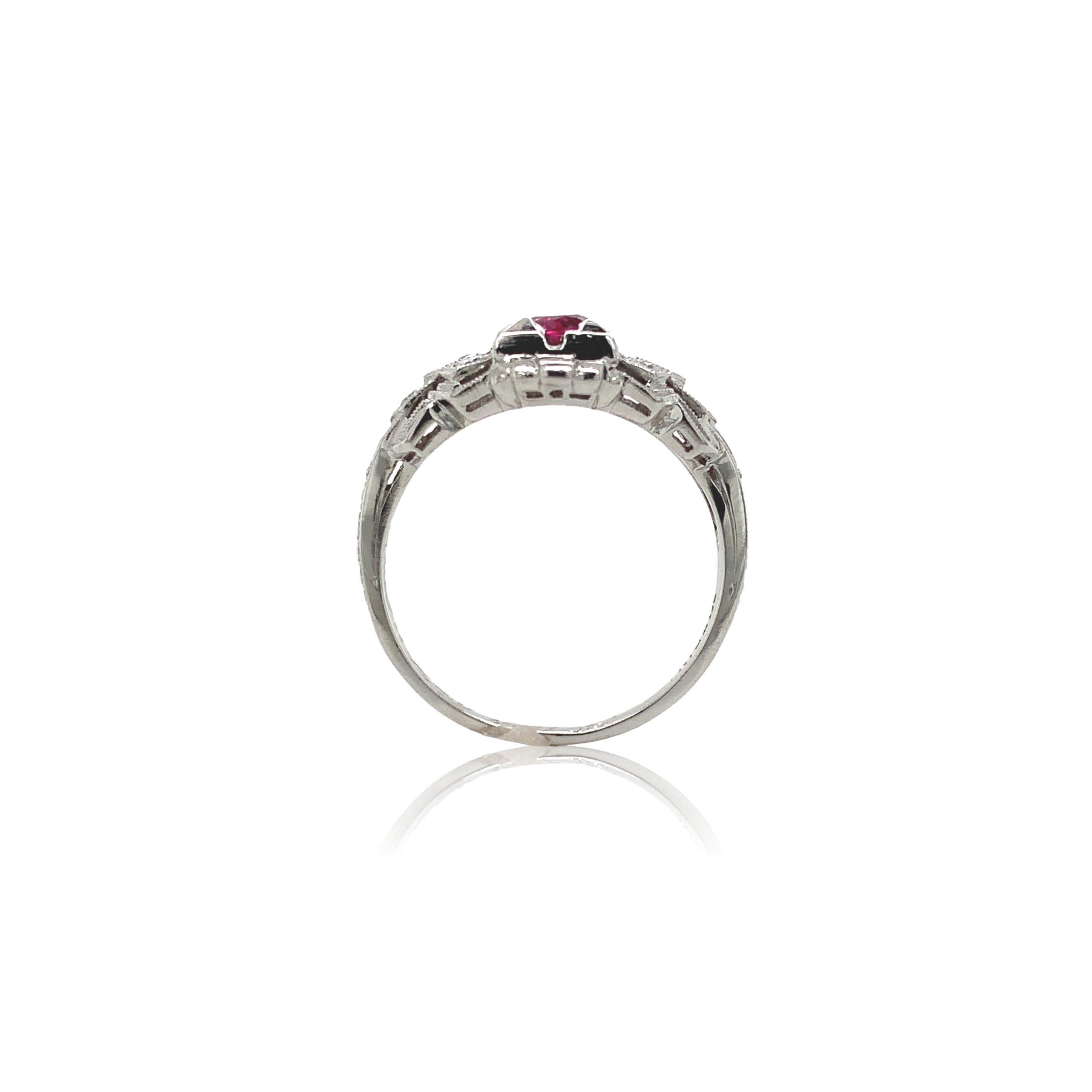 Vintage platinum ruby and diamond ring. The ring features a genuine earth mined round pinkish-red ruby weighing .31cts. The ruby measures about 4mm. There are 6 small round brilliant cut diamond accents measuring about 1.5mm. There is chased design