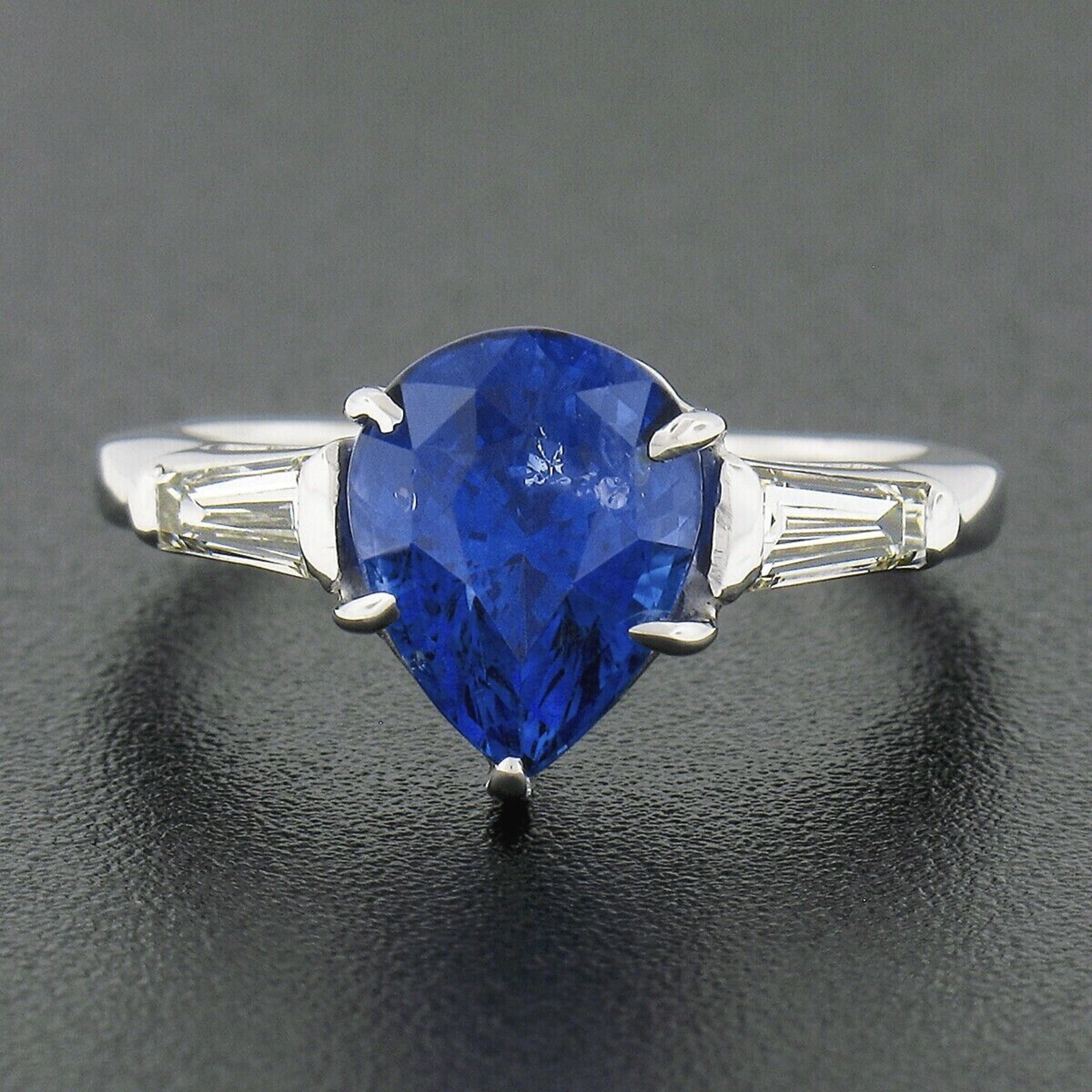 You are looking at a truly breathtaking sapphire and diamond three stone vintage ring that is crafted in solid platinum. The ring features a stunning, GIA certified, pear brilliant cut sapphire solitaire neatly prong set in the center basket and is