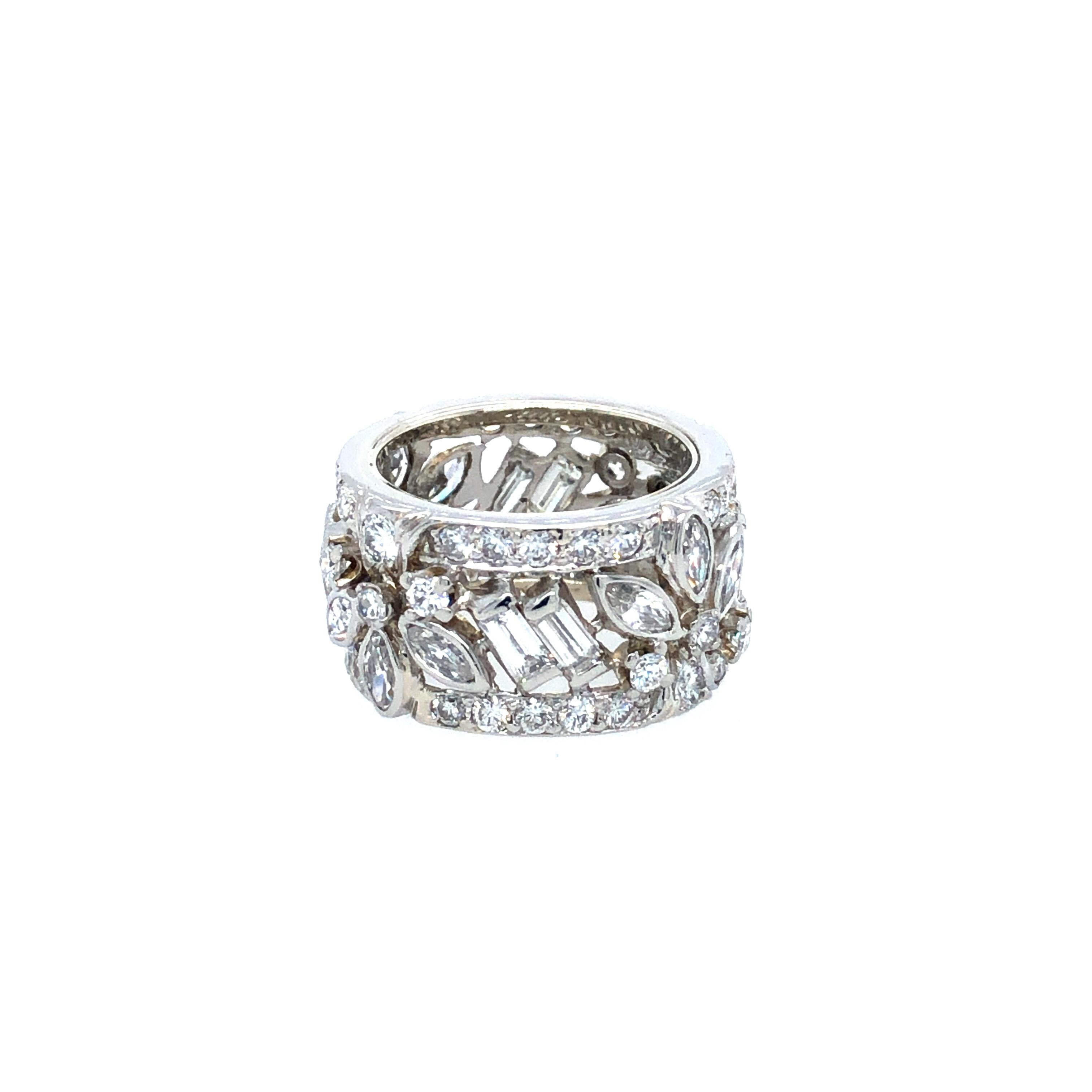 Offered here is a one of a kind platinum band, custom made circa 1960. 
An open work design band, adorned with 116 natural earth mined diamonds, 12 marquise shapes, 8 straight baguette cut and 96 transitional round cut diamonds weighing